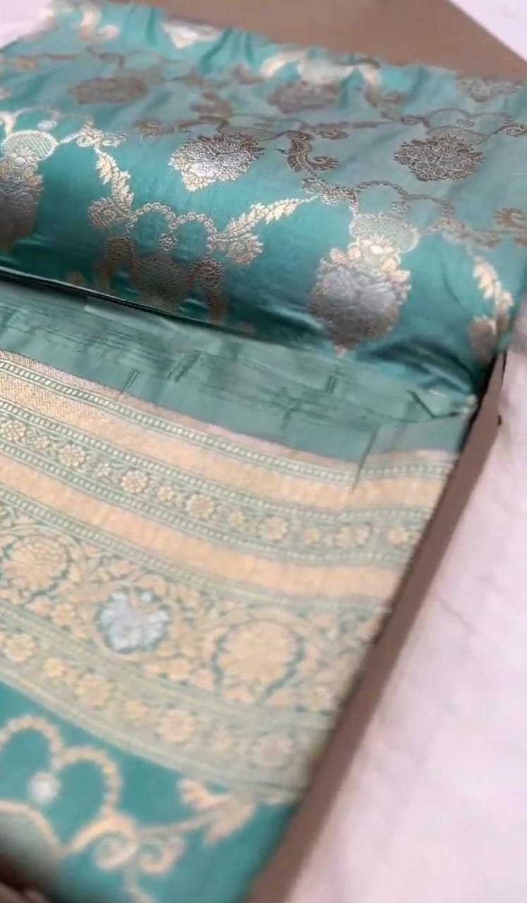 A vibrant turquoise Banarasi Katan silk saree with hand-woven Sona Rupa gold and silver zari floral motifs and an ornate border.