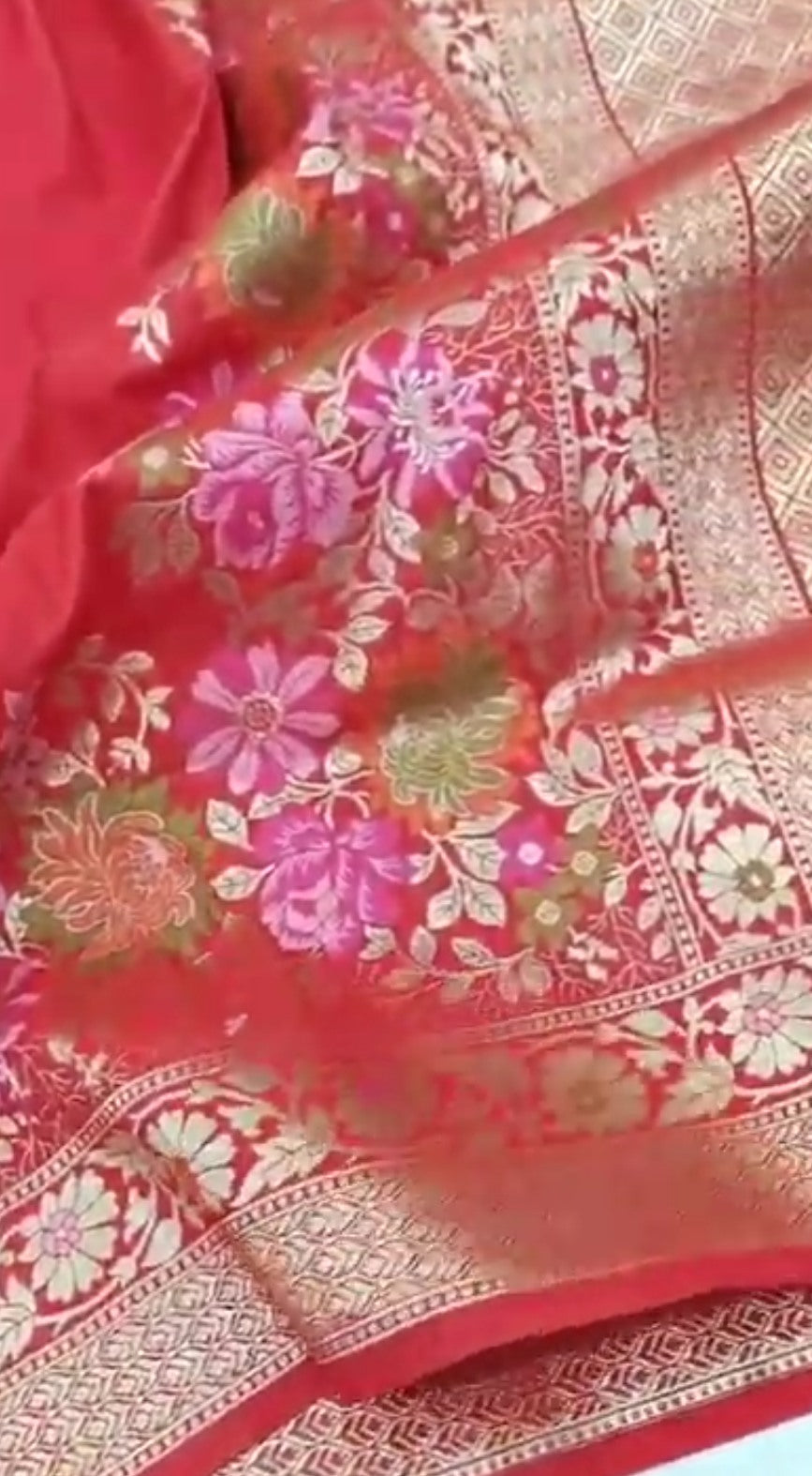 A bright bridal red Banarasi semi Katan silk saree with a minimalist plain body, intricate Tilfi Meenakari floral borders, and a heavy gold zari brocade blouse.