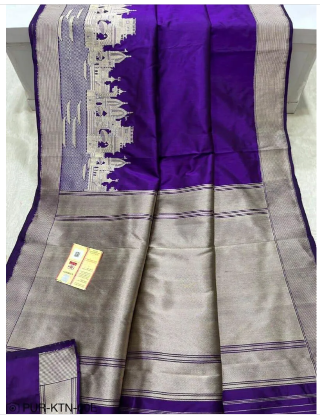 A royal purple Banarasi Katan silk saree with a silver and gold zari Kashi Ghat temple motif border and a Silk Mark Certification tag.