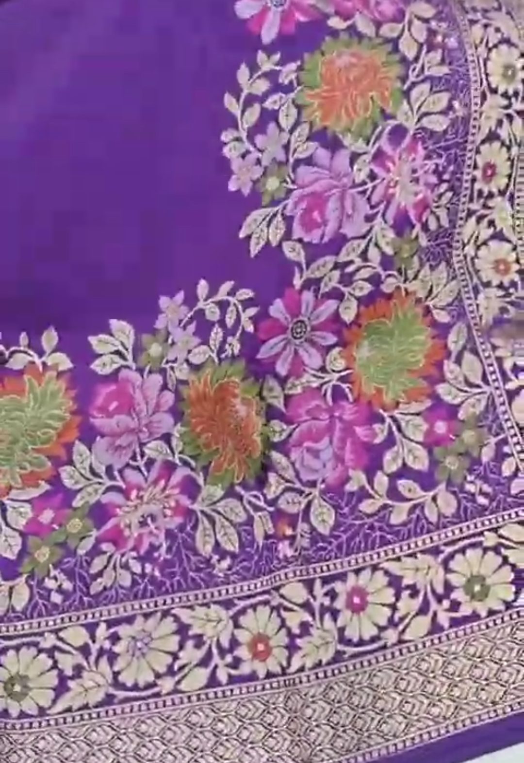 A soft lilac Banarasi semi Katan silk saree with a minimalist plain body, intricate multi-colored Tilfi Meenakari floral borders, and a matching gold zari brocade blouse.