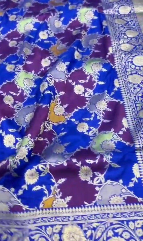 A deep azure blue Banarasi Katan silk saree featuring hand-woven Rangkaat diagonal color blocks and intricate Meenakari floral vines in gold zari.