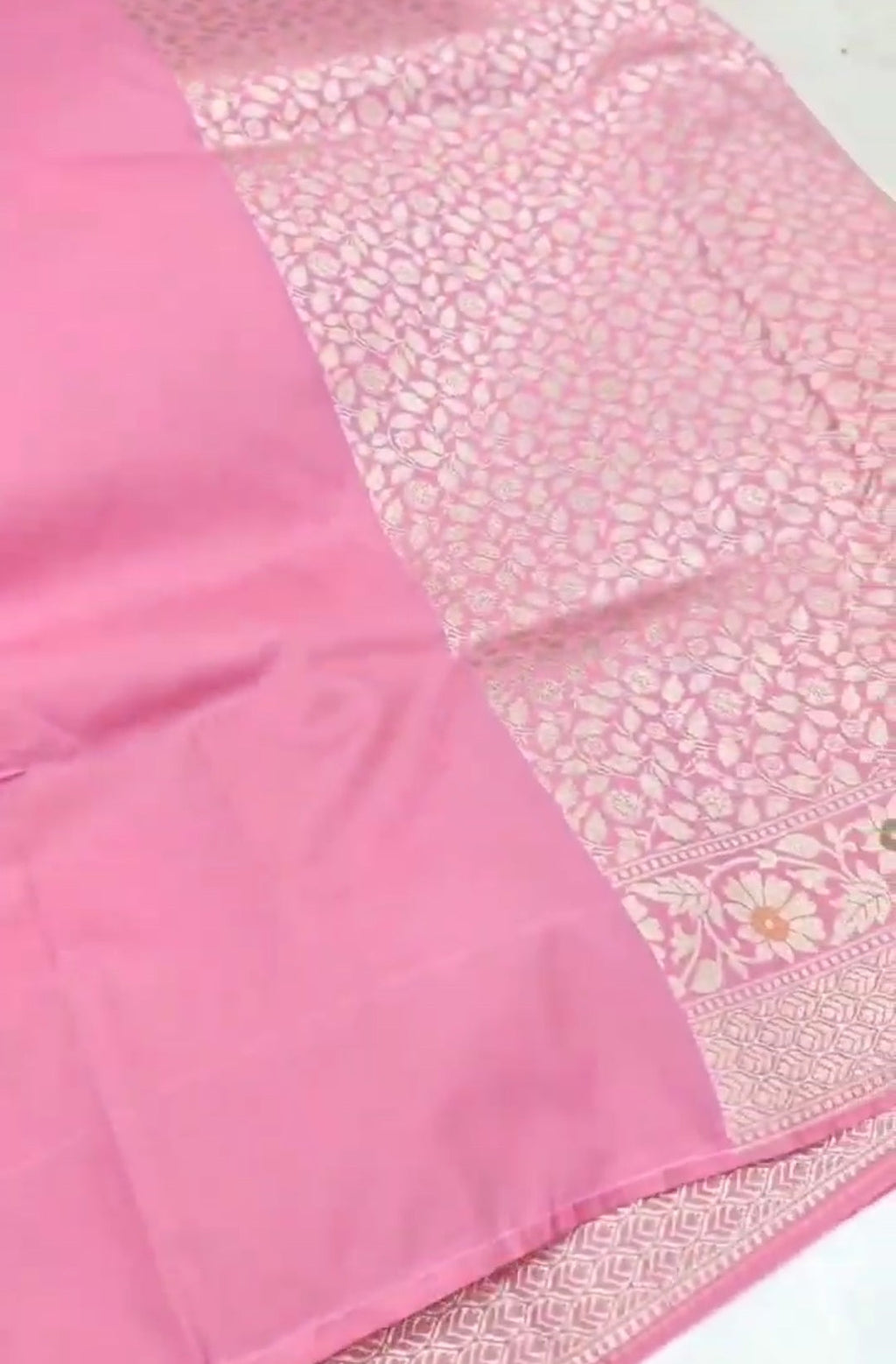 A soft pastel pink Banarasi saree with a plain silk body, a heavy Tilfi Meenakari floral border, and a matching full brocade blouse piece.