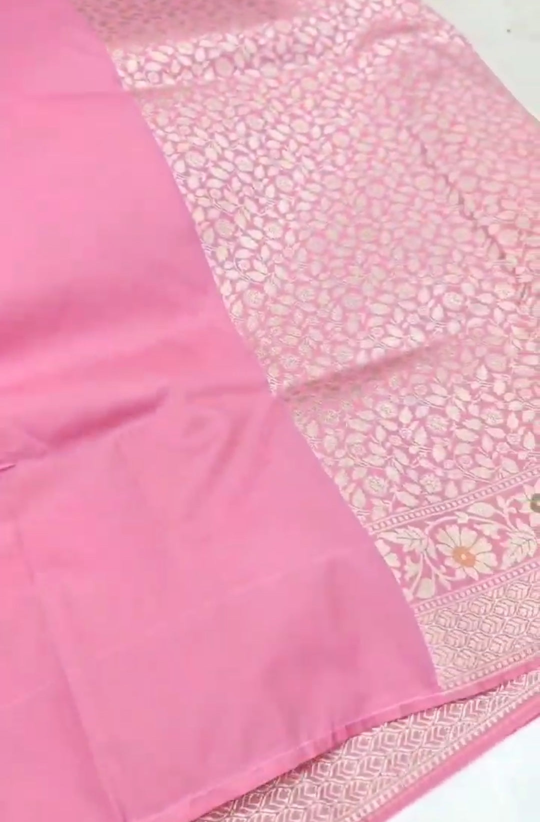 A soft pastel pink Banarasi saree with a plain silk body, a heavy Tilfi Meenakari floral border, and a matching full brocade blouse piece.