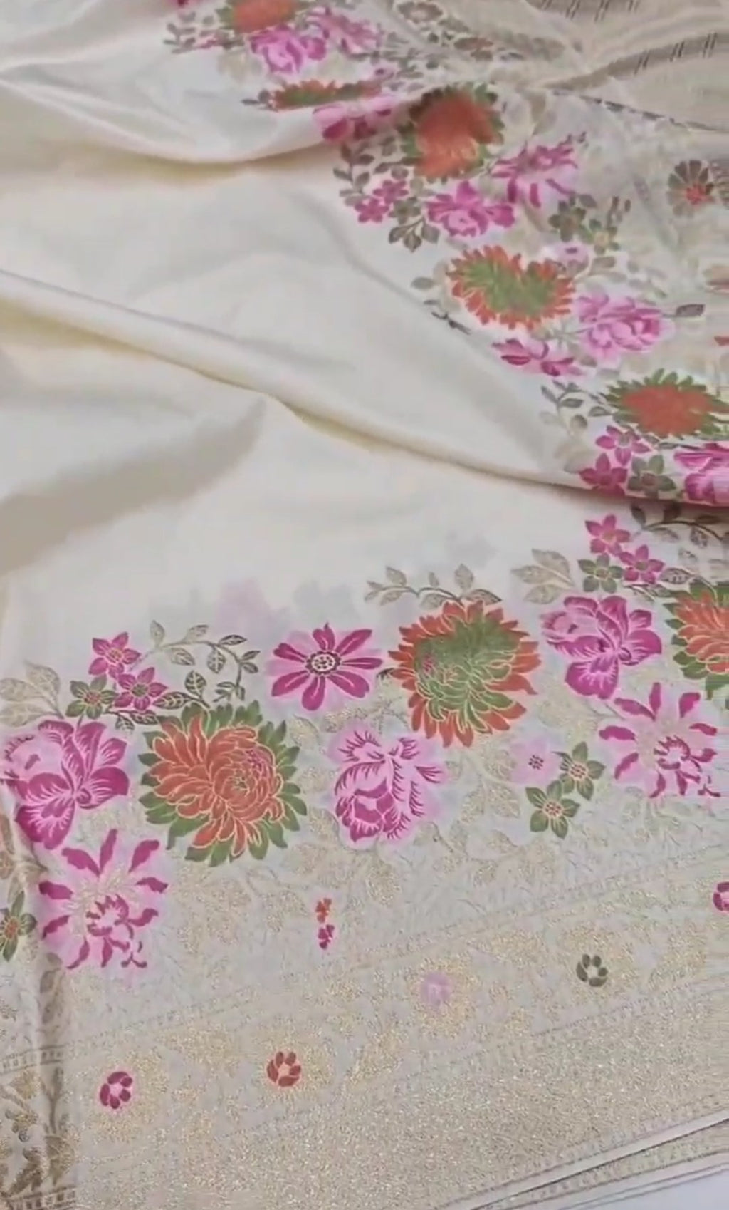 A majestic cream Banarasi semi Katan silk saree with a minimalist plain body, multi-colored Tilfi Meenakari floral borders, and a heavy gold zari blouse.