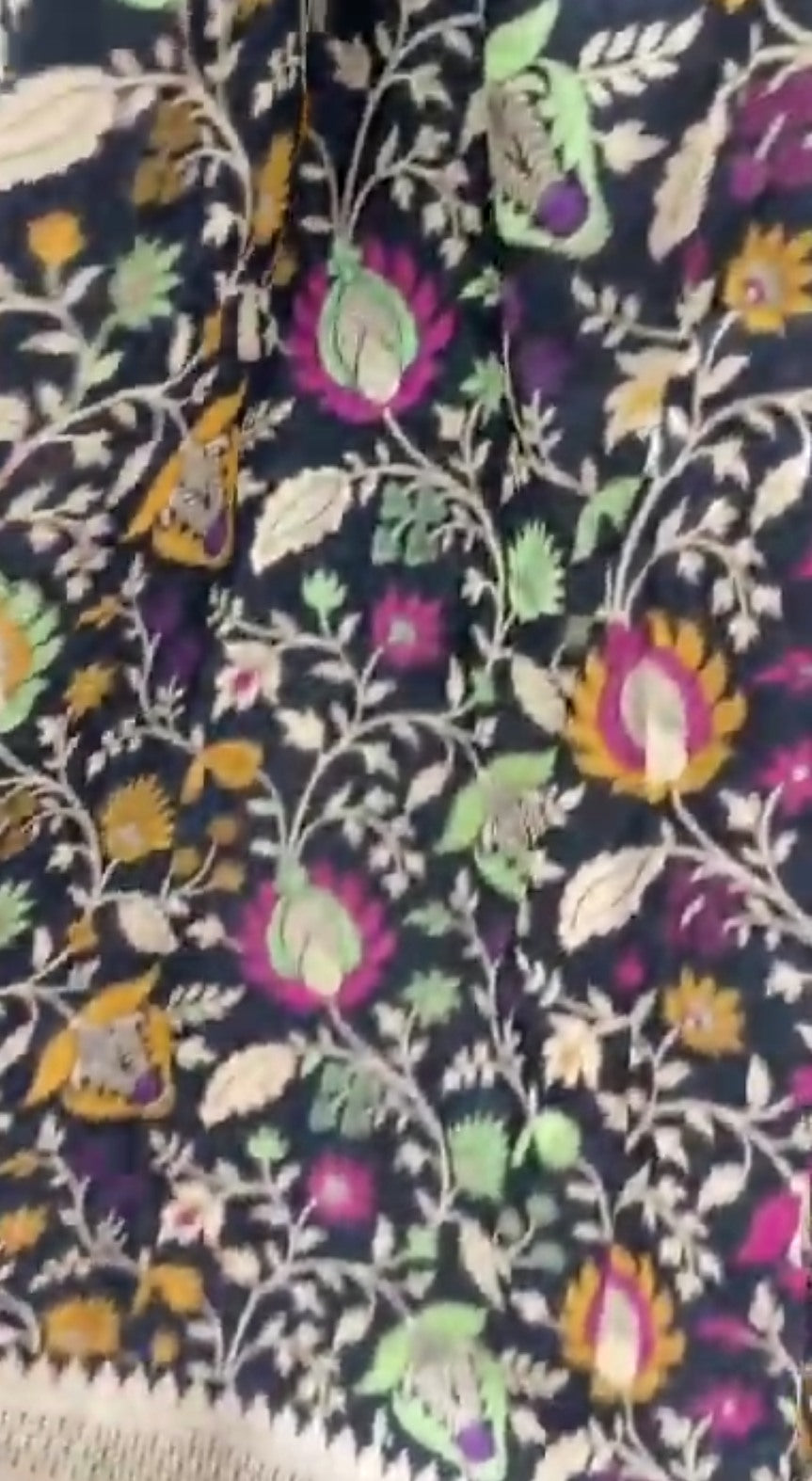 A royal black Banarasi Katan silk saree featuring colorful Tilfi Meenakari floral buttas and an intricate gold zari border.