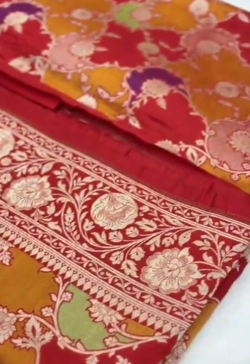 A majestic red Banarasi Katan silk saree with Rangkaat multi-color diagonal patterns and intricate hand-woven Meenakari floral jal.