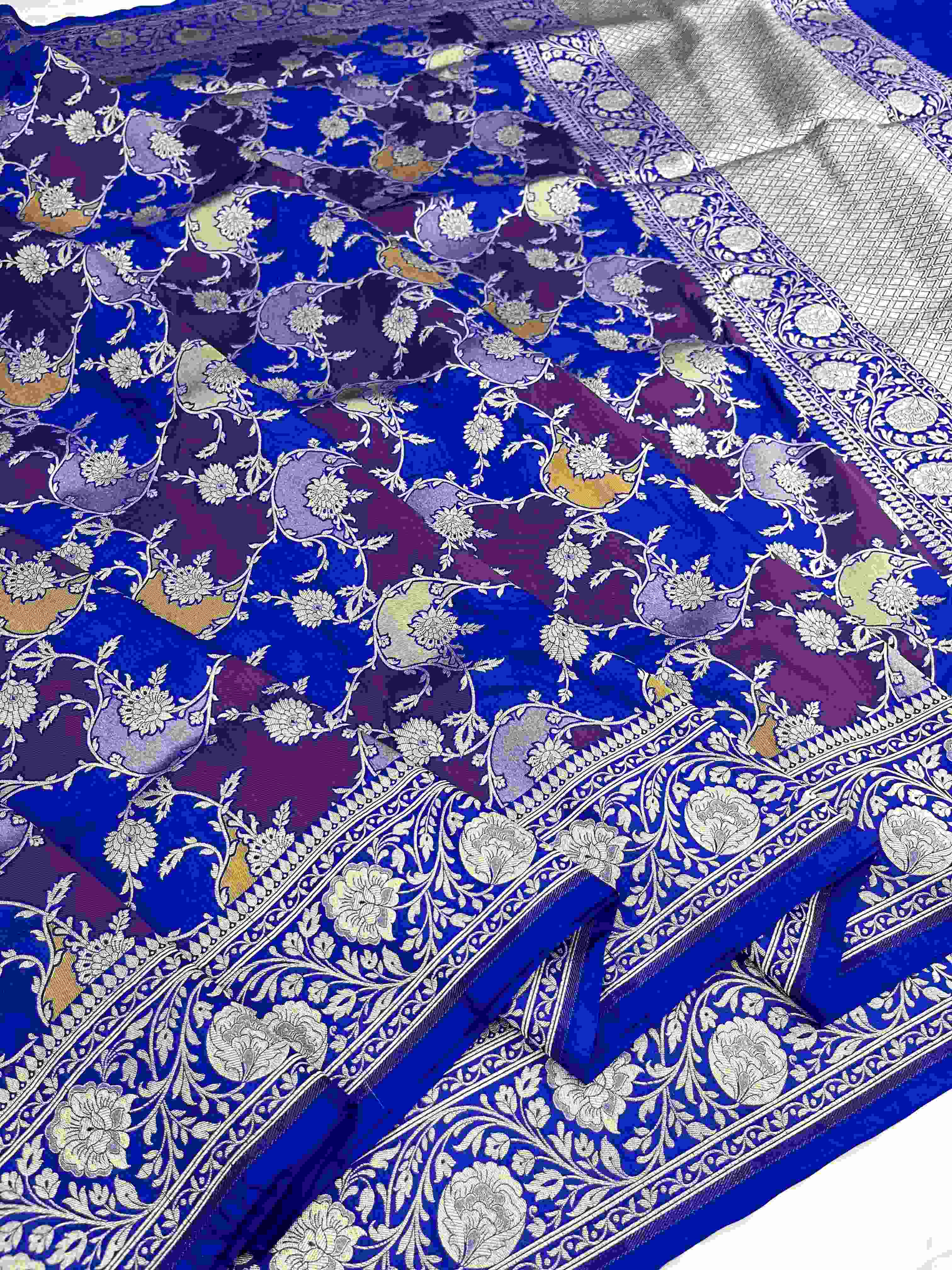 A deep azure blue Banarasi Katan silk saree featuring hand-woven Rangkaat diagonal color blocks and intricate Meenakari floral vines in gold zari.