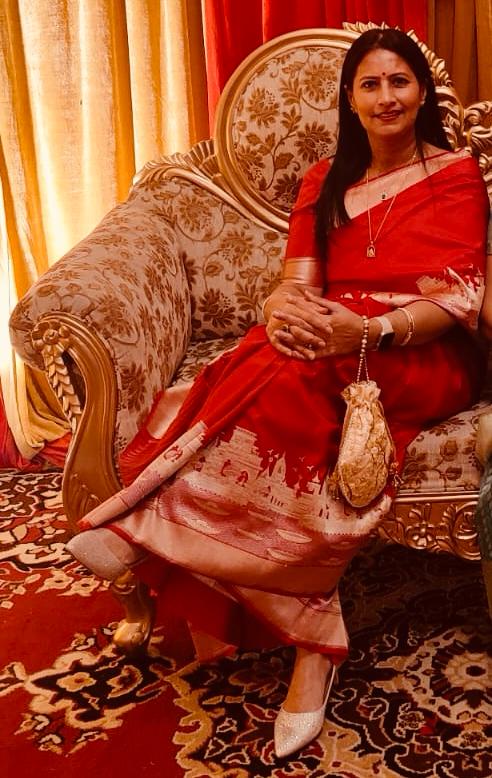 A vibrant red Banarasi Katan silk saree with a handloom-woven Kashi Ghat temple motif border in gold and silver zari with Meenakari accents.