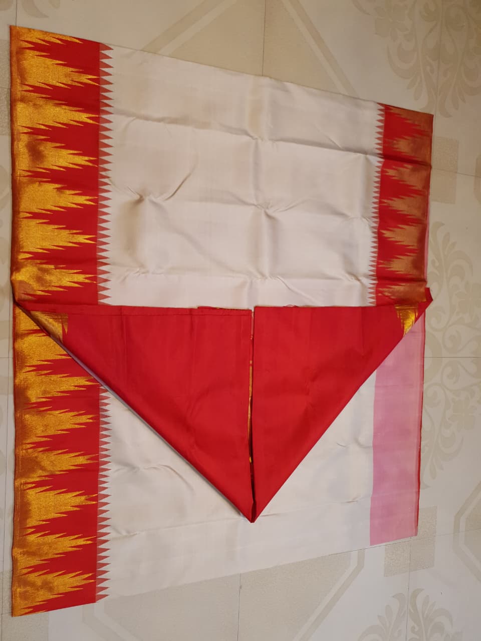 Beige Kanchipuram Handloom Silk Saree with a red Korvai temple border and 2G gold zari motifs in a South Indian temple setting.