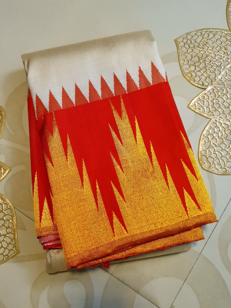 Beige Kanchipuram Handloom Silk Saree with a red Korvai temple border and 2G gold zari motifs in a South Indian temple setting.