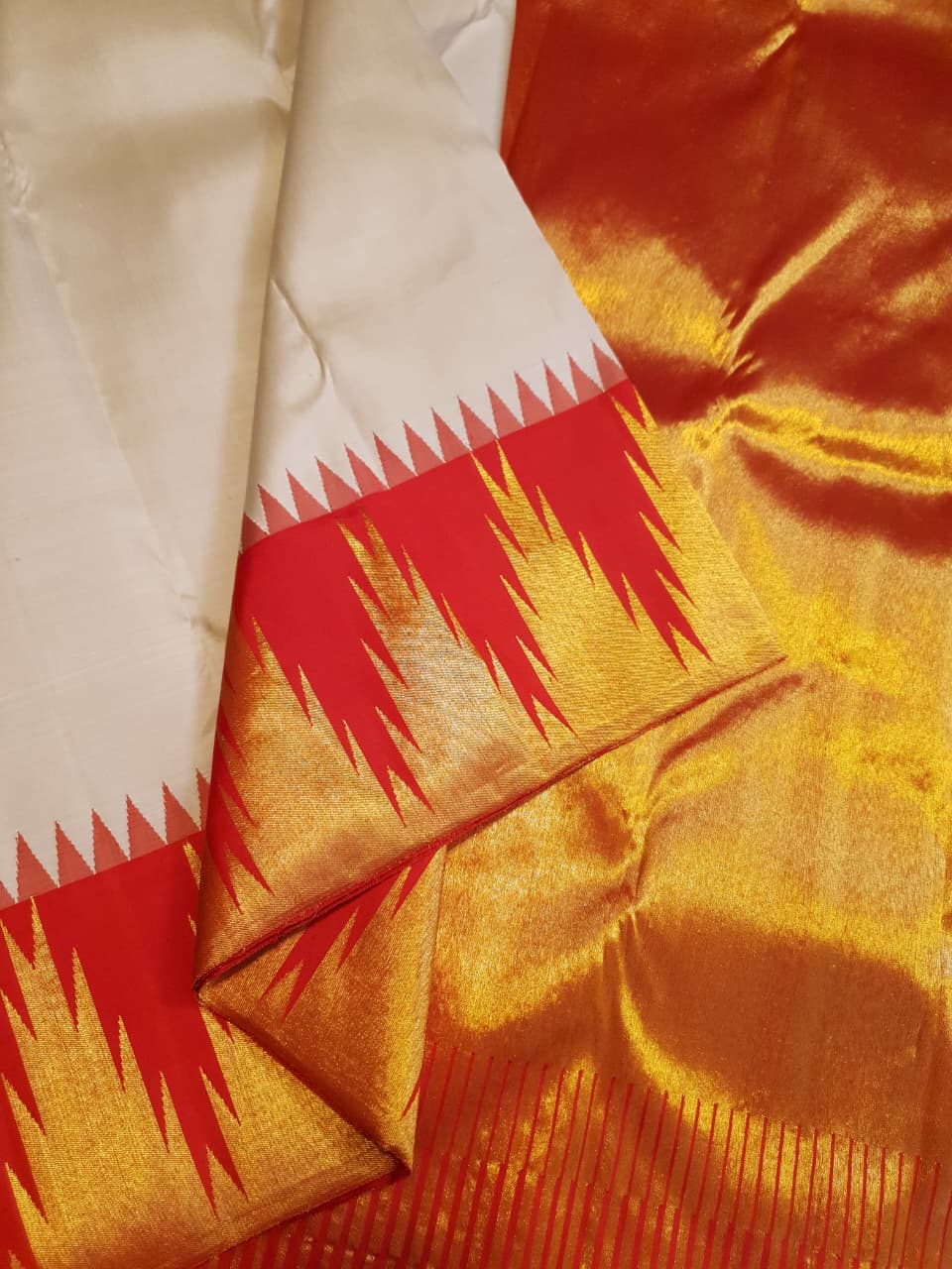 Beige Kanchipuram Handloom Silk Saree with a red Korvai temple border and 2G gold zari motifs in a South Indian temple setting.