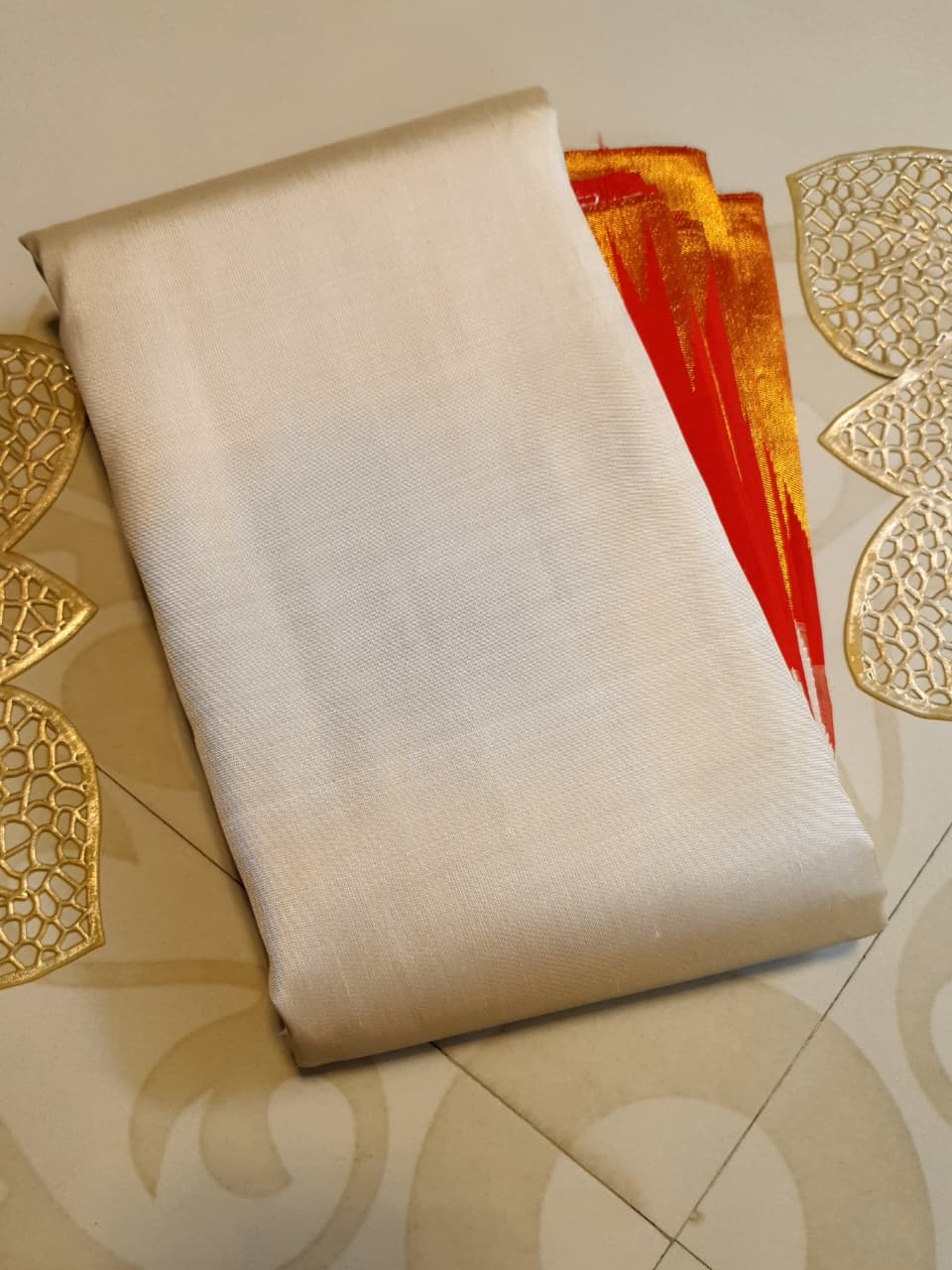 Beige Kanchipuram Handloom Silk Saree with a red Korvai temple border and 2G gold zari motifs in a South Indian temple setting.