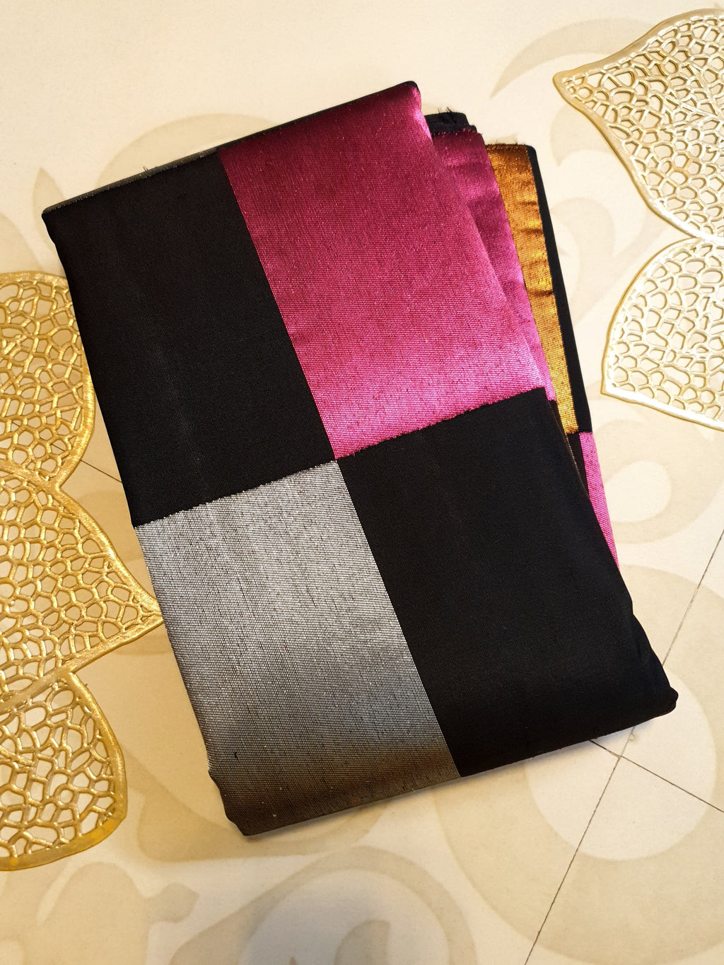 A luxurious multicolor 2G Kanchipuram pattu silk saree featuring a bold checkered pattern in black, pink, gold, and silver, displayed elegantly with traditional weaves.