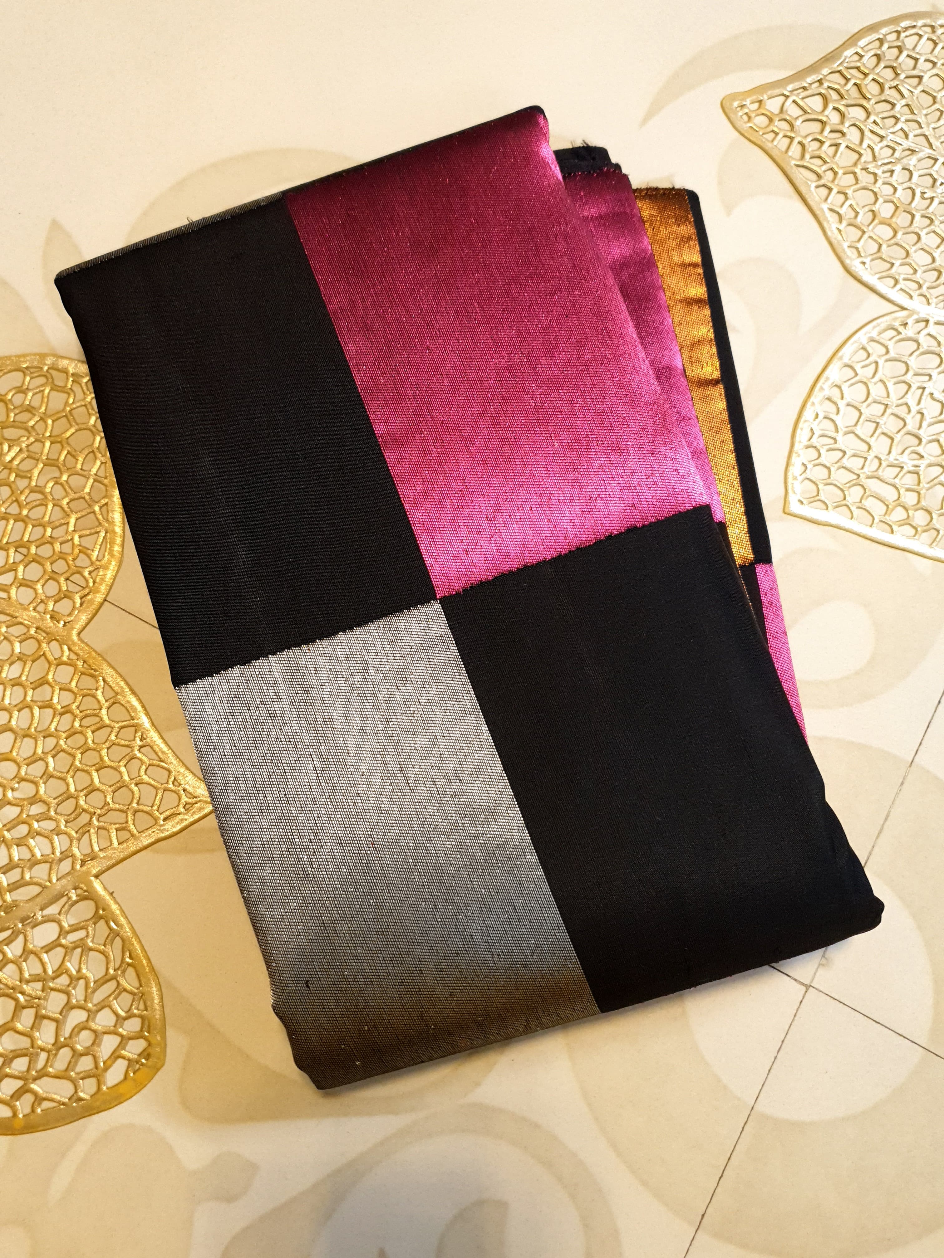 A luxurious multicolor 2G Kanchipuram pattu silk saree featuring a bold checkered pattern in black, pink, gold, and silver, displayed elegantly with traditional weaves.
