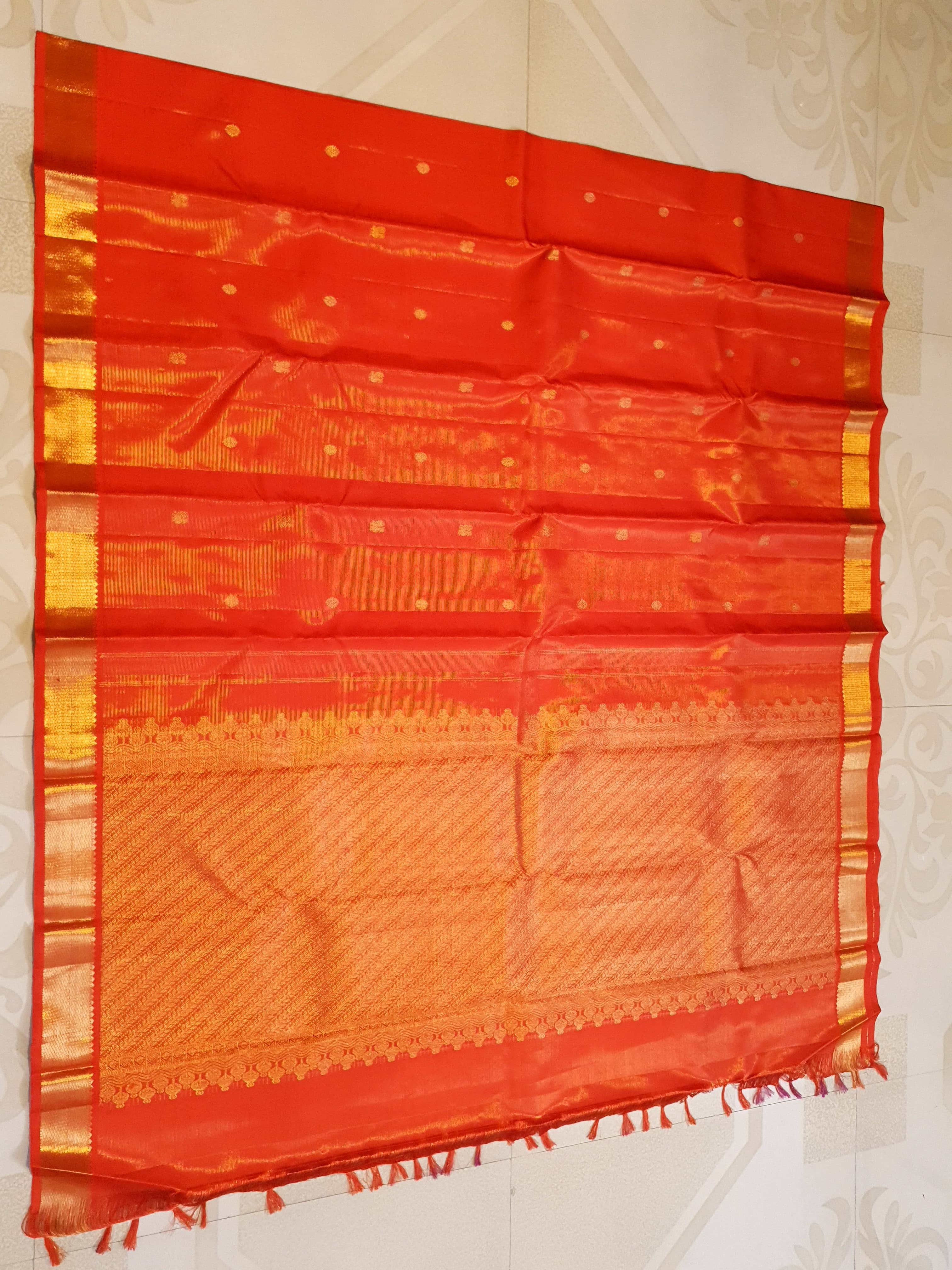 Vibrant Chilly Red Kanjivaram silk saree with a traditional gold zari border and small buttis.