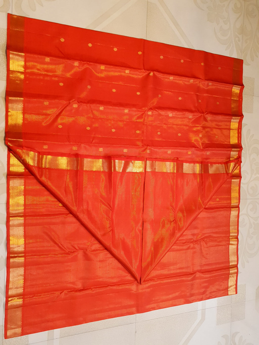 Vibrant Chilly Red Kanjivaram silk saree with a traditional gold zari border and small buttis.