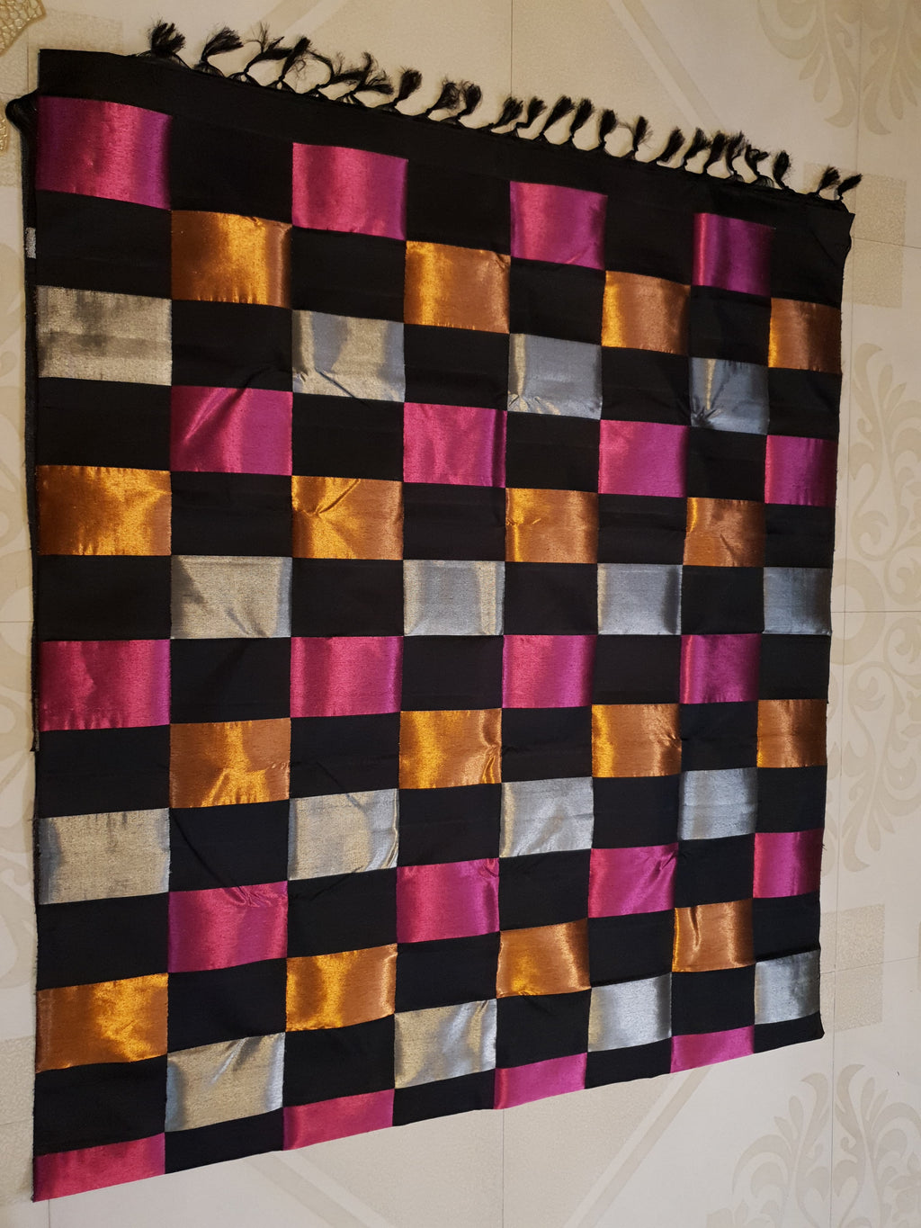 A luxurious multicolor 2G Kanchipuram pattu silk saree featuring a bold checkered pattern in black, pink, gold, and silver, displayed elegantly with traditional weaves.