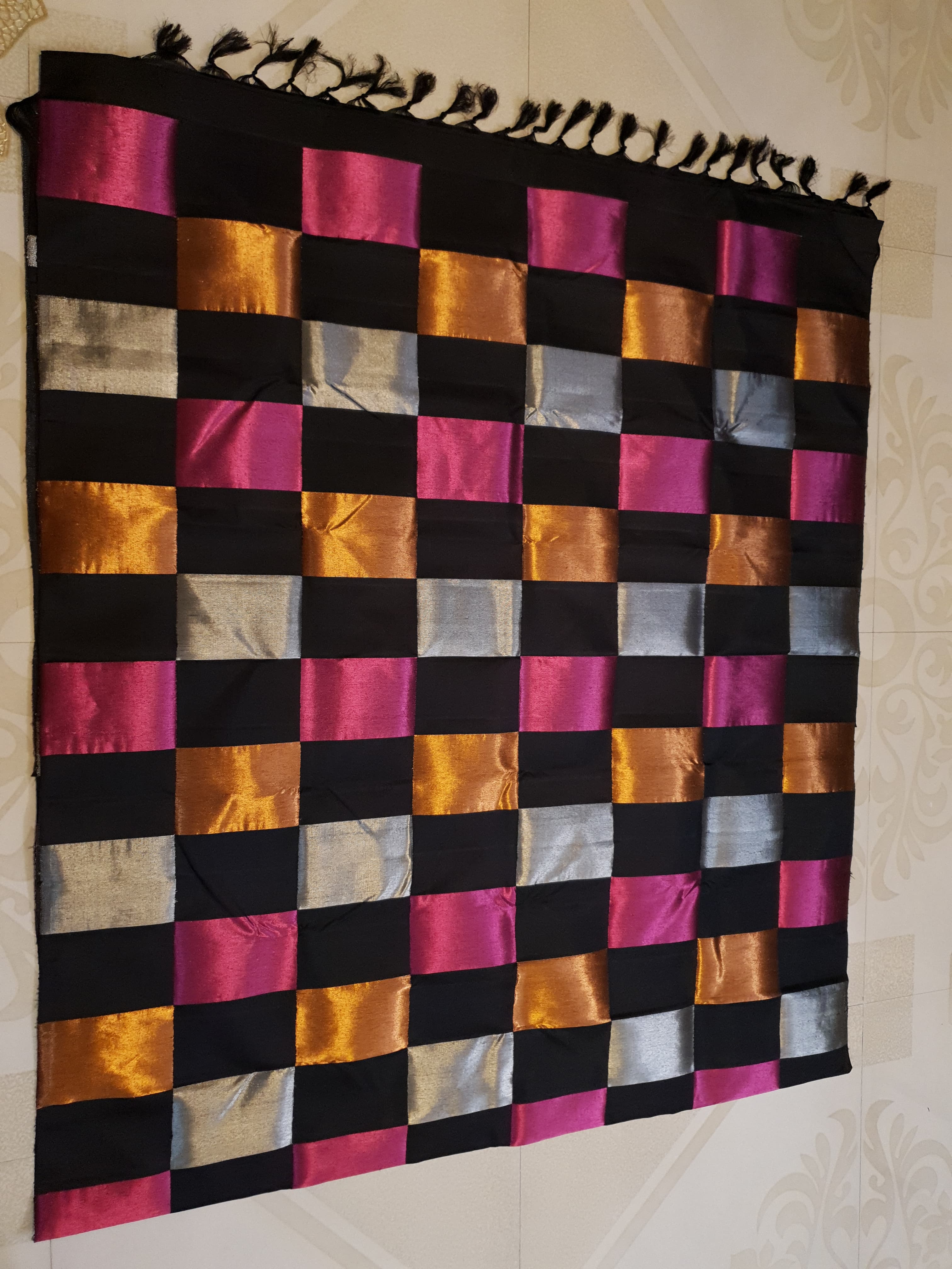 A luxurious multicolor 2G Kanchipuram pattu silk saree featuring a bold checkered pattern in black, pink, gold, and silver, displayed elegantly with traditional weaves.