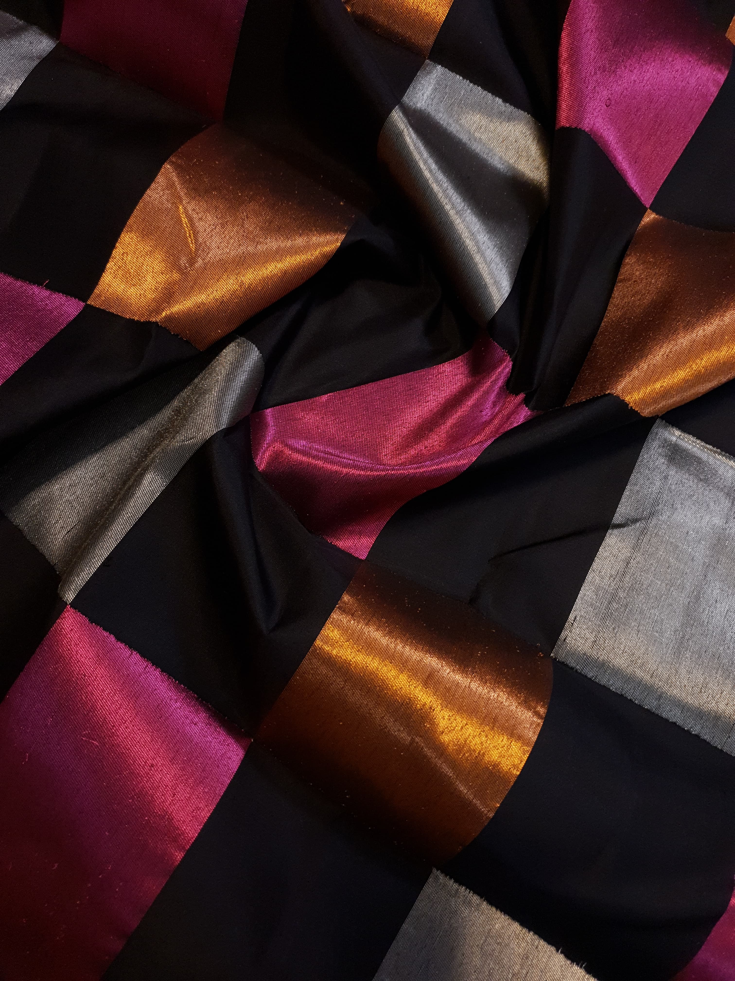 A luxurious multicolor 2G Kanchipuram pattu silk saree featuring a bold checkered pattern in black, pink, gold, and silver, displayed elegantly with traditional weaves.