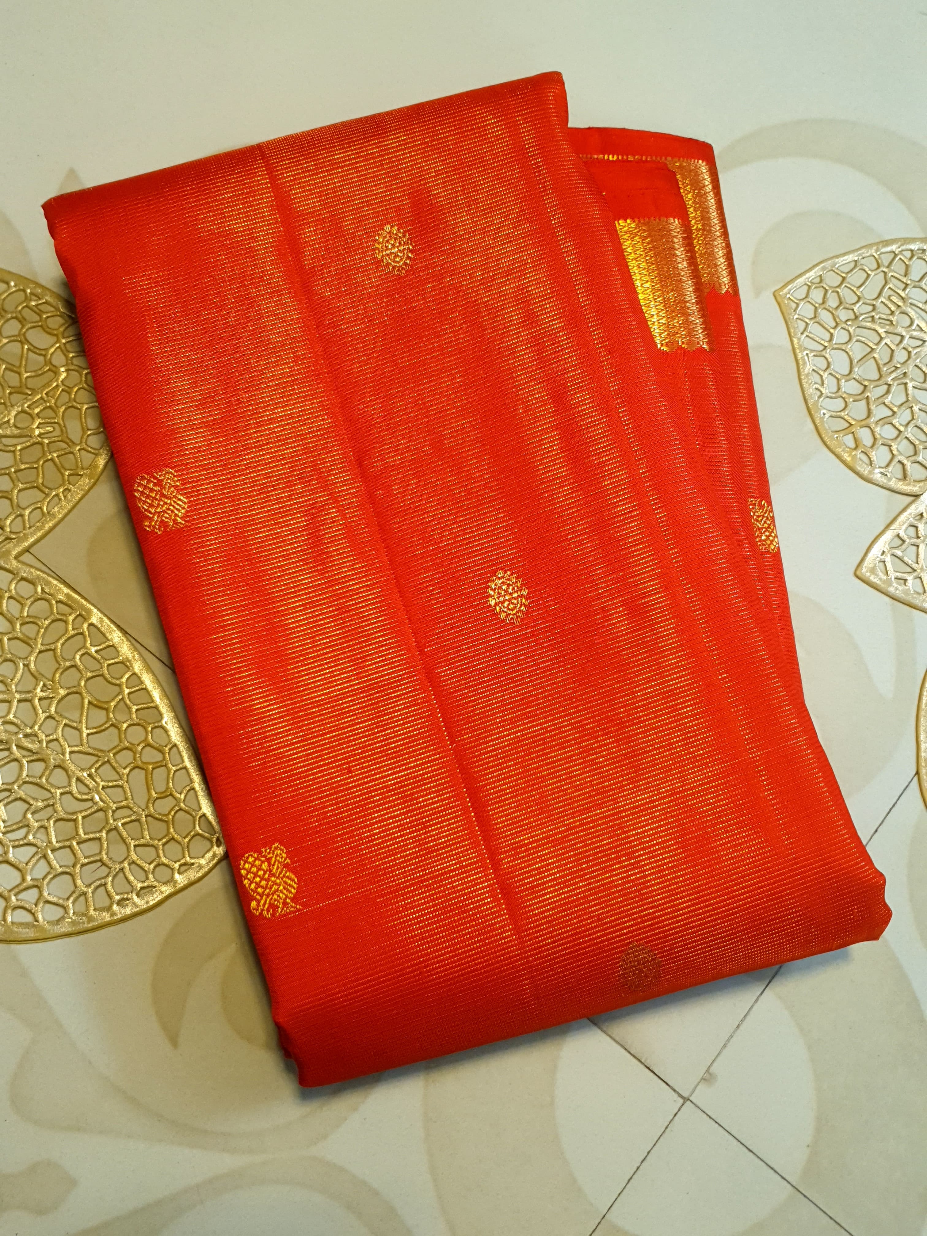 Vibrant Chilly Red Kanjivaram silk saree with a traditional gold zari border and small buttis.