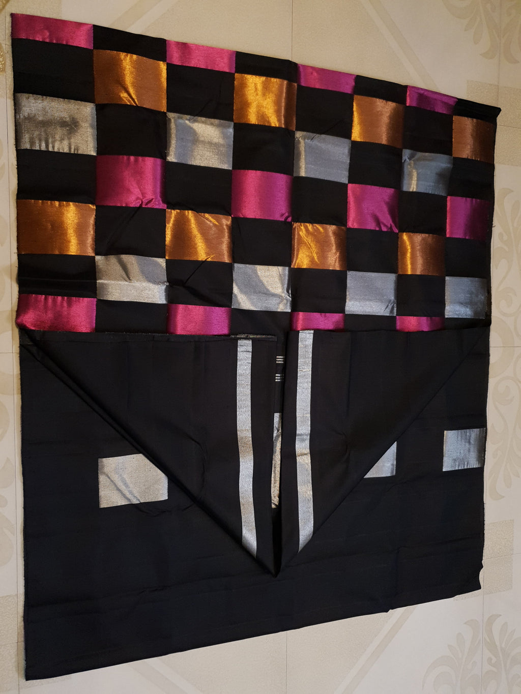 A luxurious multicolor 2G Kanchipuram pattu silk saree featuring a bold checkered pattern in black, pink, gold, and silver, displayed elegantly with traditional weaves.