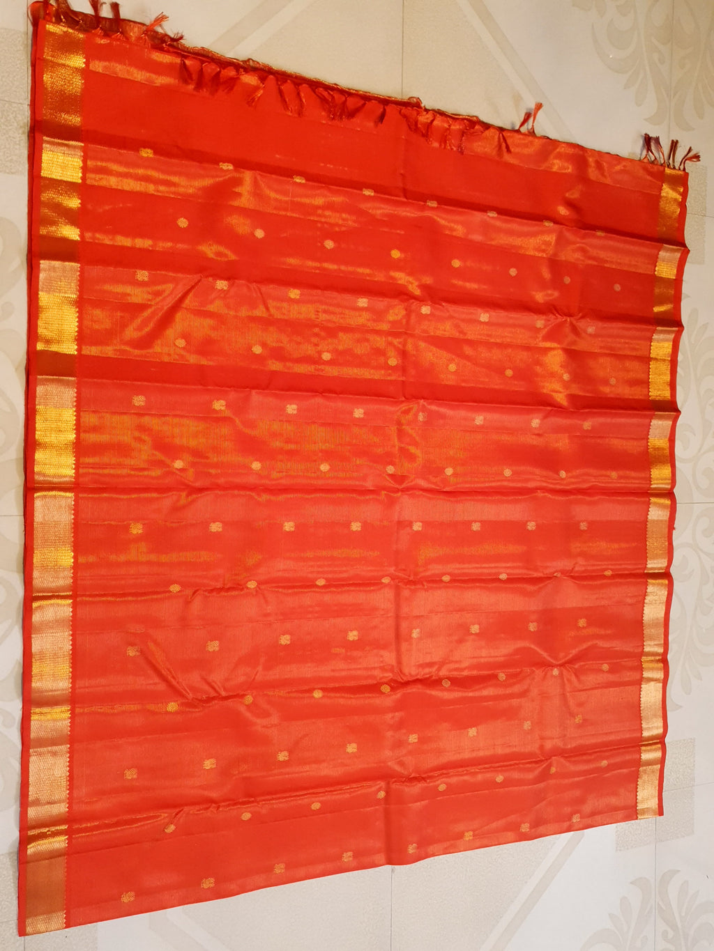 Vibrant Chilly Red Kanjivaram silk saree with a traditional gold zari border and small buttis.