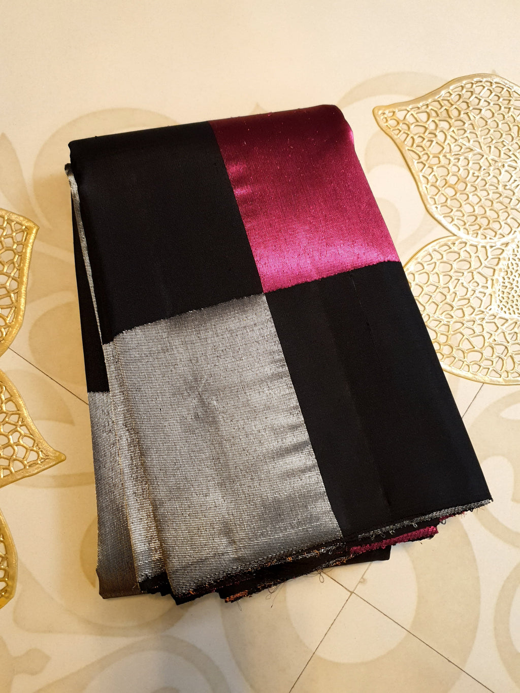 A luxurious multicolor 2G Kanchipuram pattu silk saree featuring a bold checkered pattern in black, pink, gold, and silver, displayed elegantly with traditional weaves.