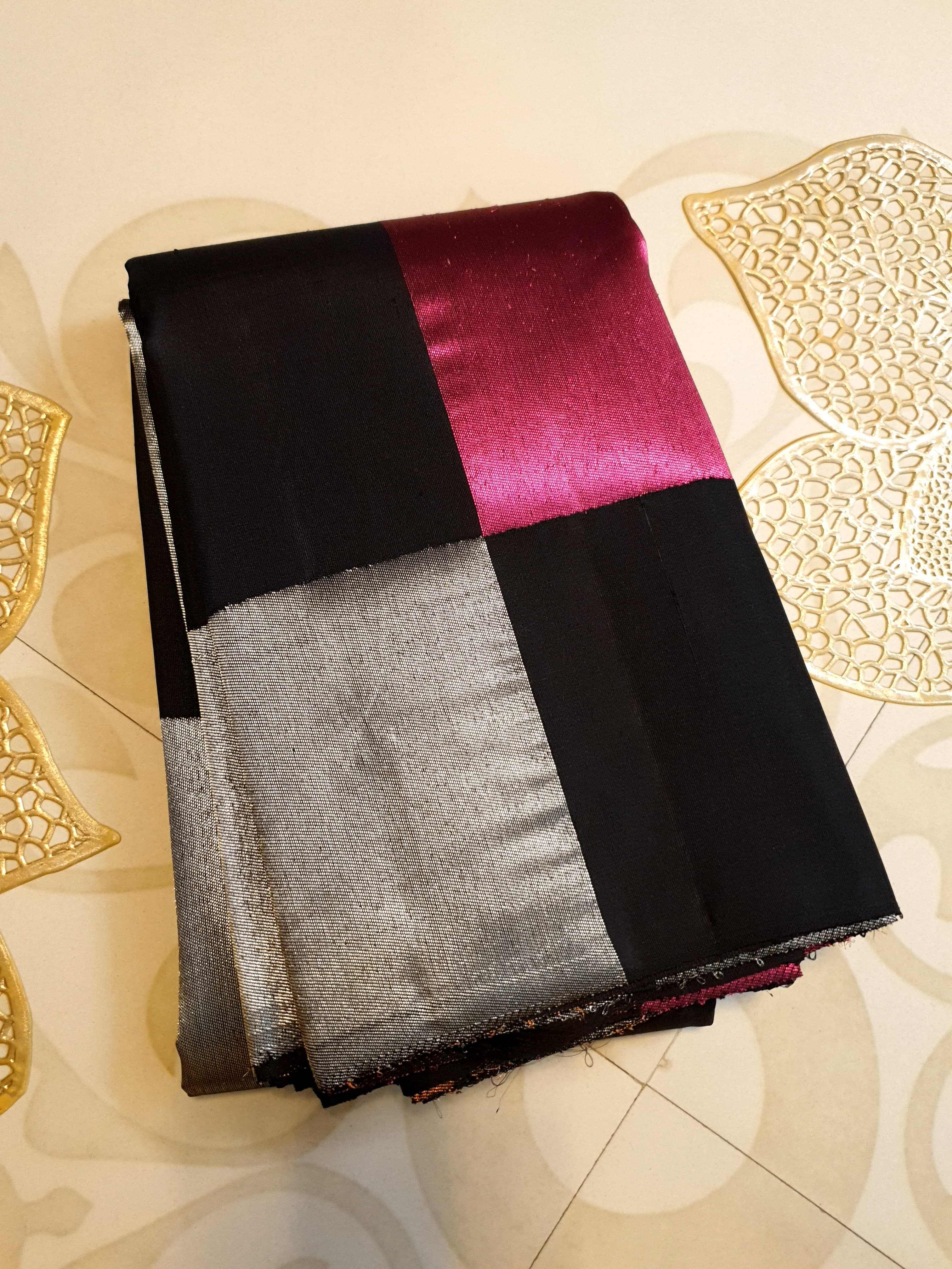 A luxurious multicolor 2G Kanchipuram pattu silk saree featuring a bold checkered pattern in black, pink, gold, and silver, displayed elegantly with traditional weaves.