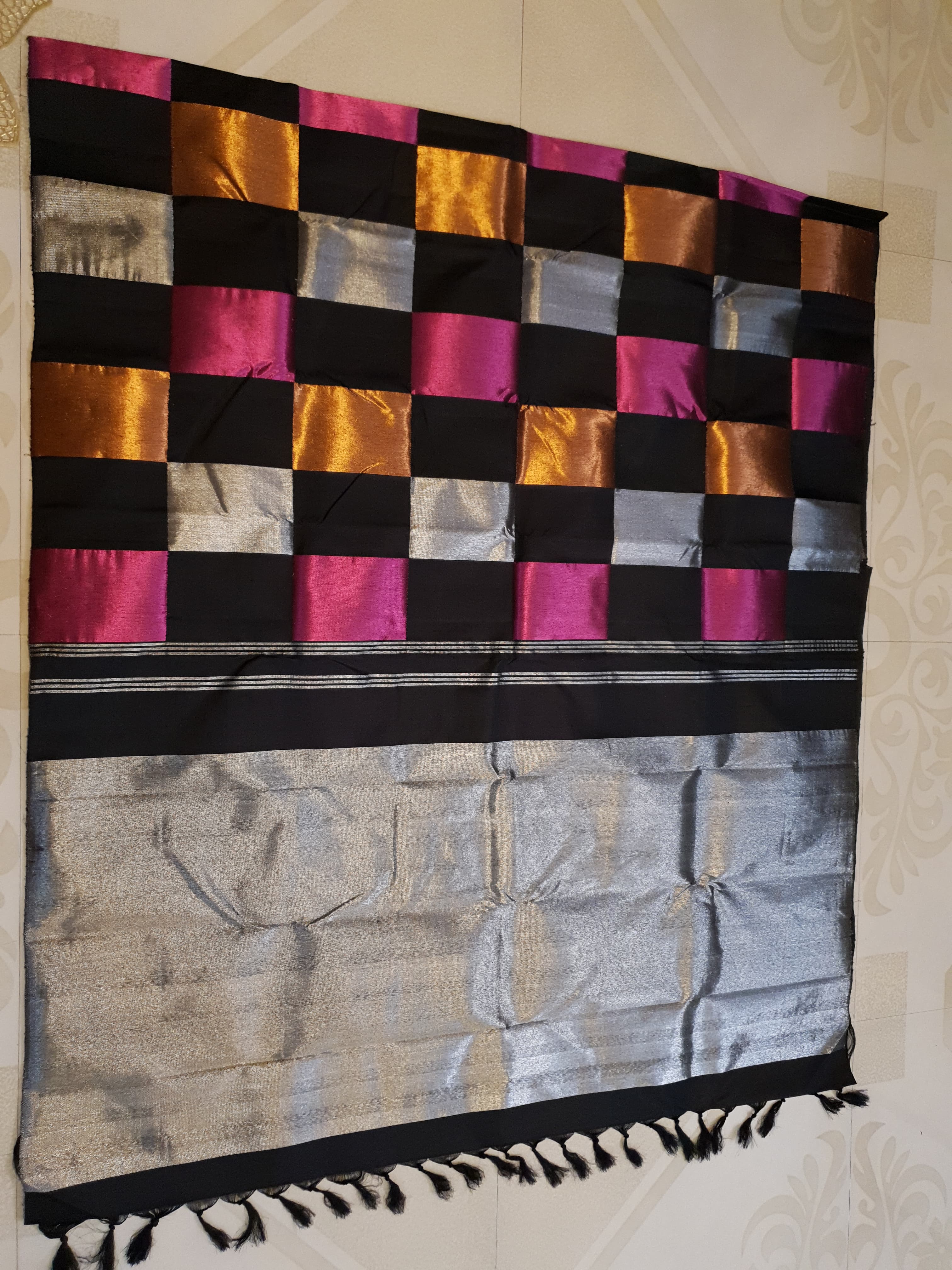 A luxurious multicolor 2G Kanchipuram pattu silk saree featuring a bold checkered pattern in black, pink, gold, and silver, displayed elegantly with traditional weaves.
