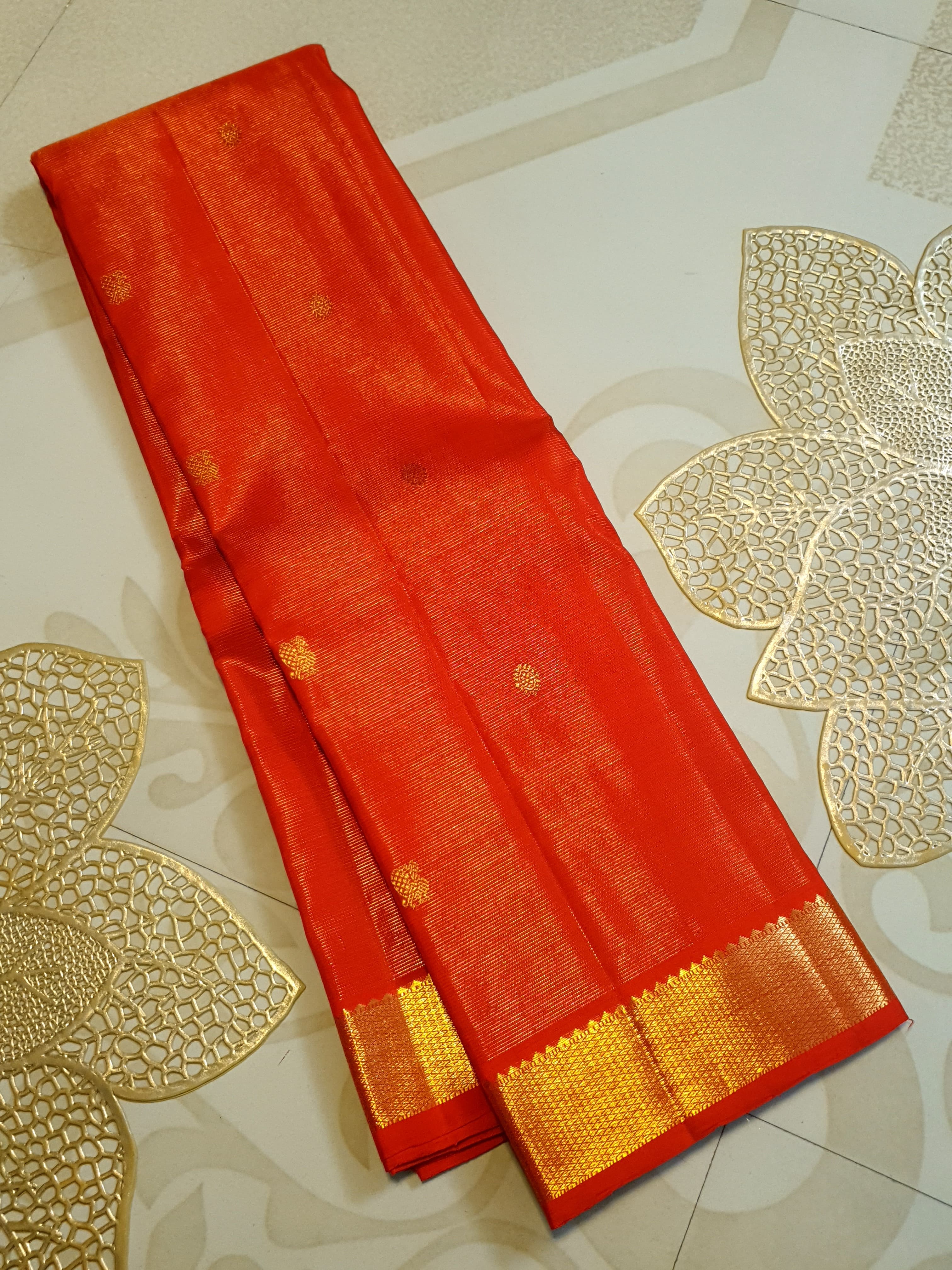 Vibrant Chilly Red Kanjivaram silk saree with a traditional gold zari border and small buttis.