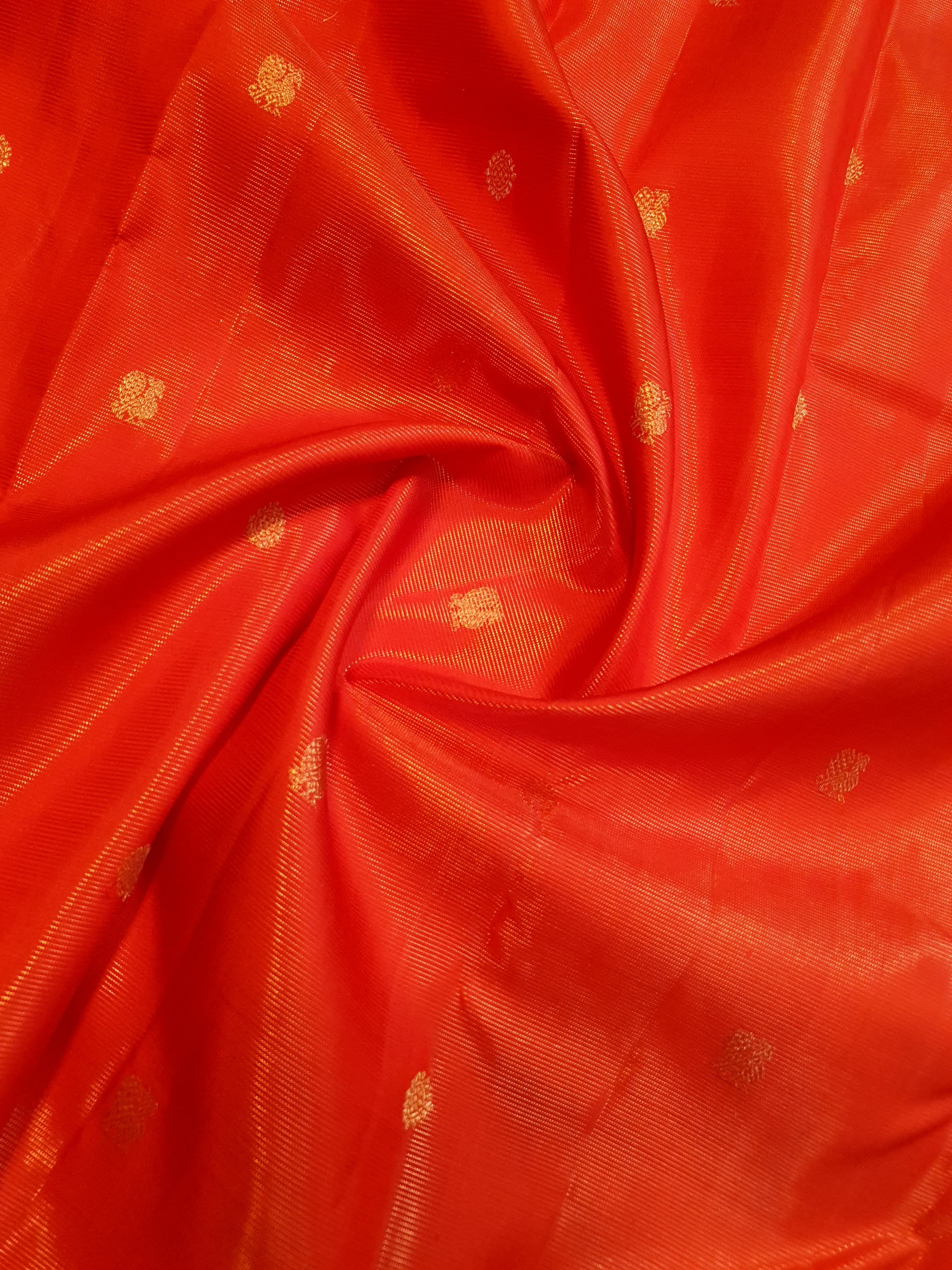Vibrant Chilly Red Kanjivaram silk saree with a traditional gold zari border and small buttis.
