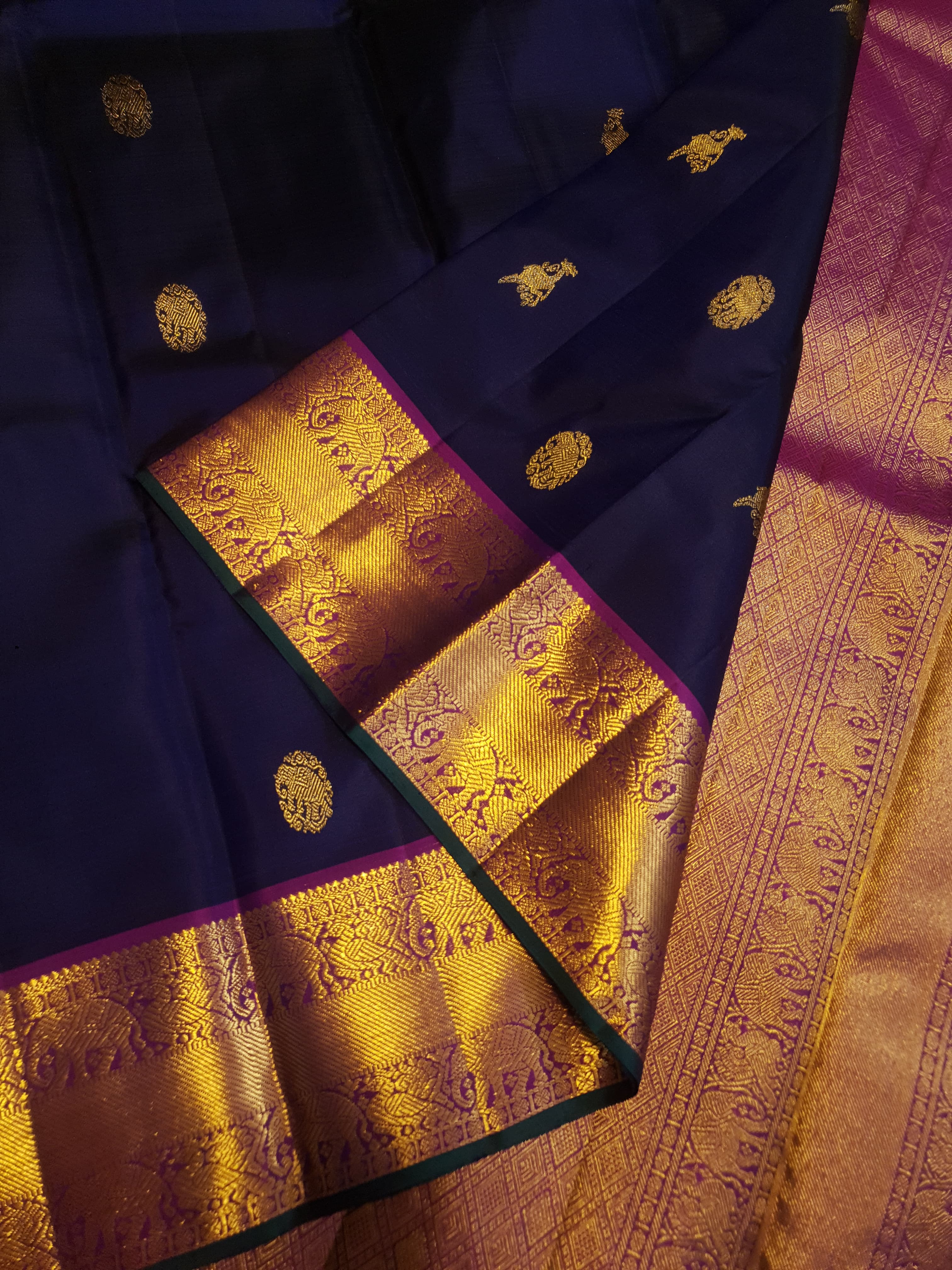 Midnight blue Kanchipuram handloom silk saree, featuring a rich gold zari border and intricate traditional gold motifs.