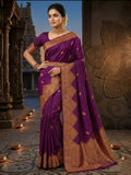 A bride in a traditional South Indian temple wears the intricate Magenta Kanchipuram Handloom 2G Gold Vairaoosi Silk Saree with matching temple jewelry.
