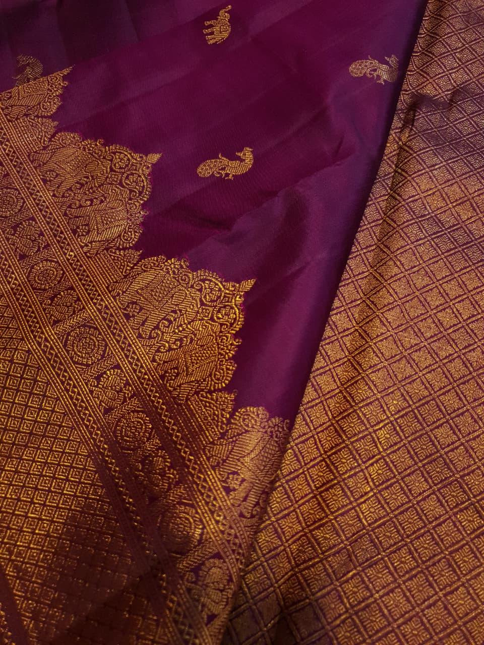 A bride in a traditional South Indian temple wears the intricate Magenta Kanchipuram Handloom 2G Gold Vairaoosi Silk Saree with matching temple jewelry.