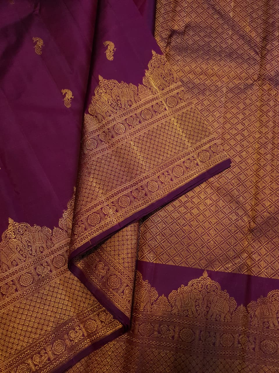 A bride in a traditional South Indian temple wears the intricate Magenta Kanchipuram Handloom 2G Gold Vairaoosi Silk Saree with matching temple jewelry.