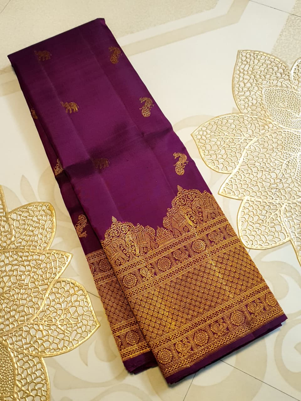 A bride in a traditional South Indian temple wears the intricate Magenta Kanchipuram Handloom 2G Gold Vairaoosi Silk Saree with matching temple jewelry.