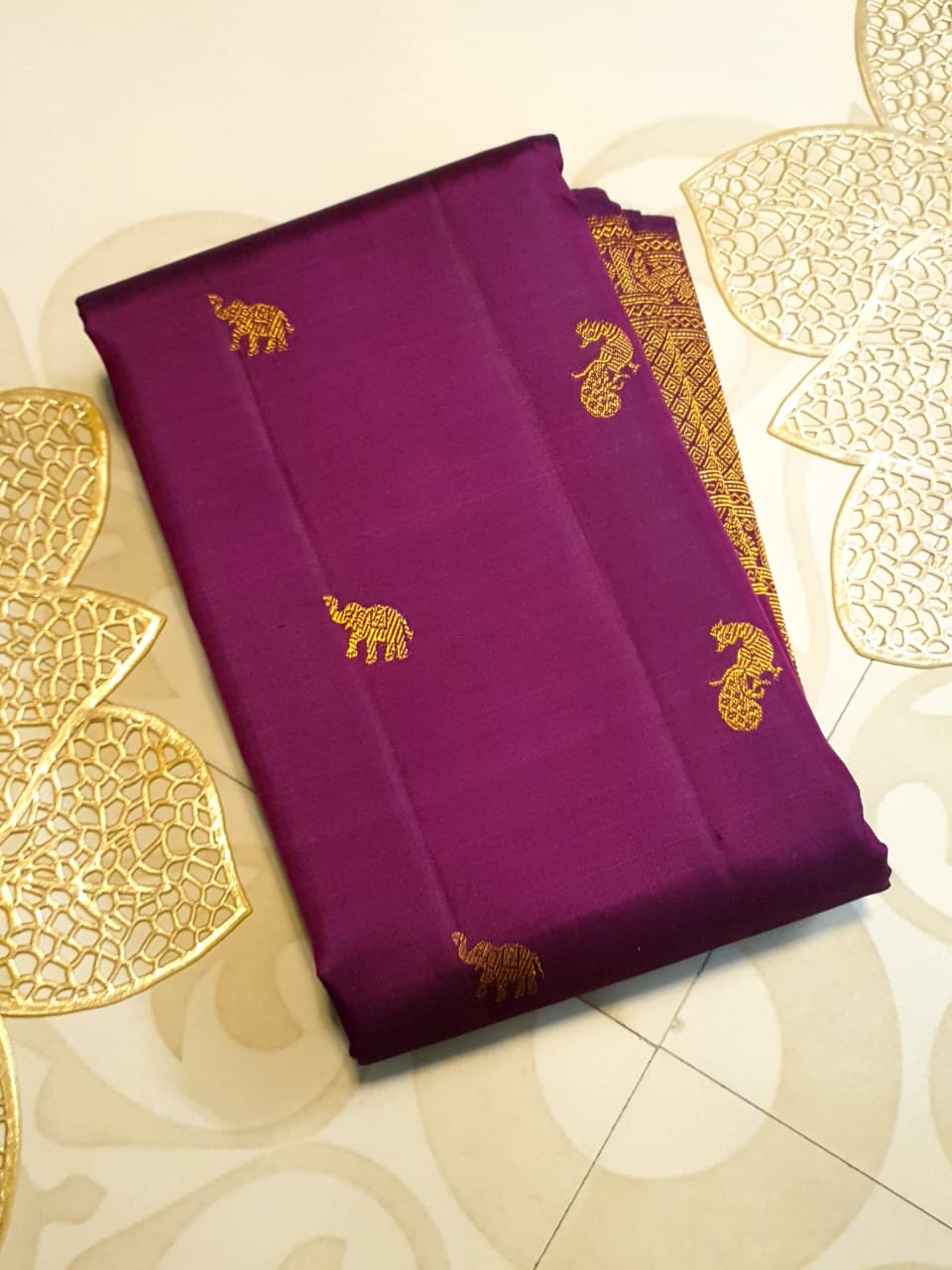 A bride in a traditional South Indian temple wears the intricate Magenta Kanchipuram Handloom 2G Gold Vairaoosi Silk Saree with matching temple jewelry.