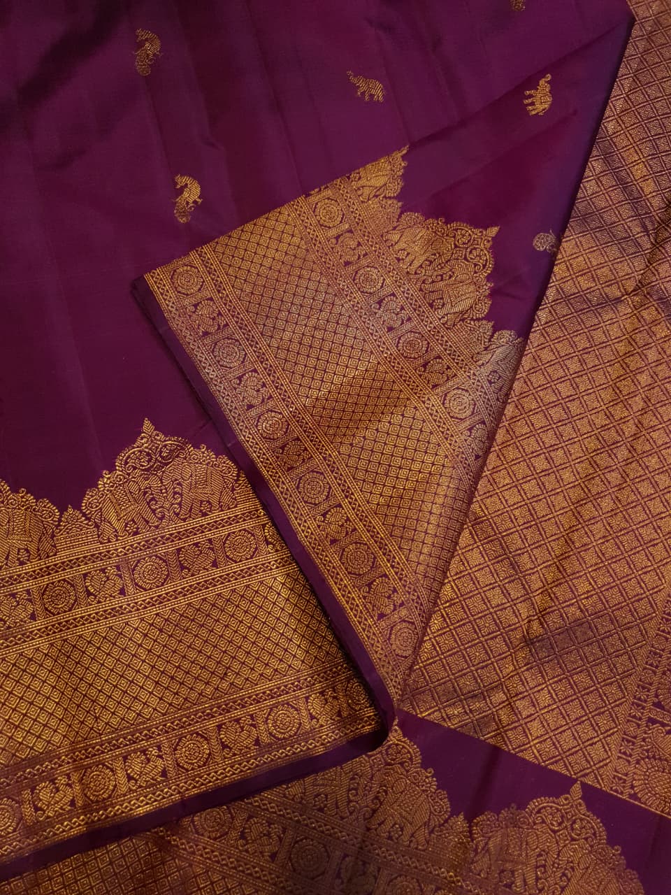 A bride in a traditional South Indian temple wears the intricate Magenta Kanchipuram Handloom 2G Gold Vairaoosi Silk Saree with matching temple jewelry.