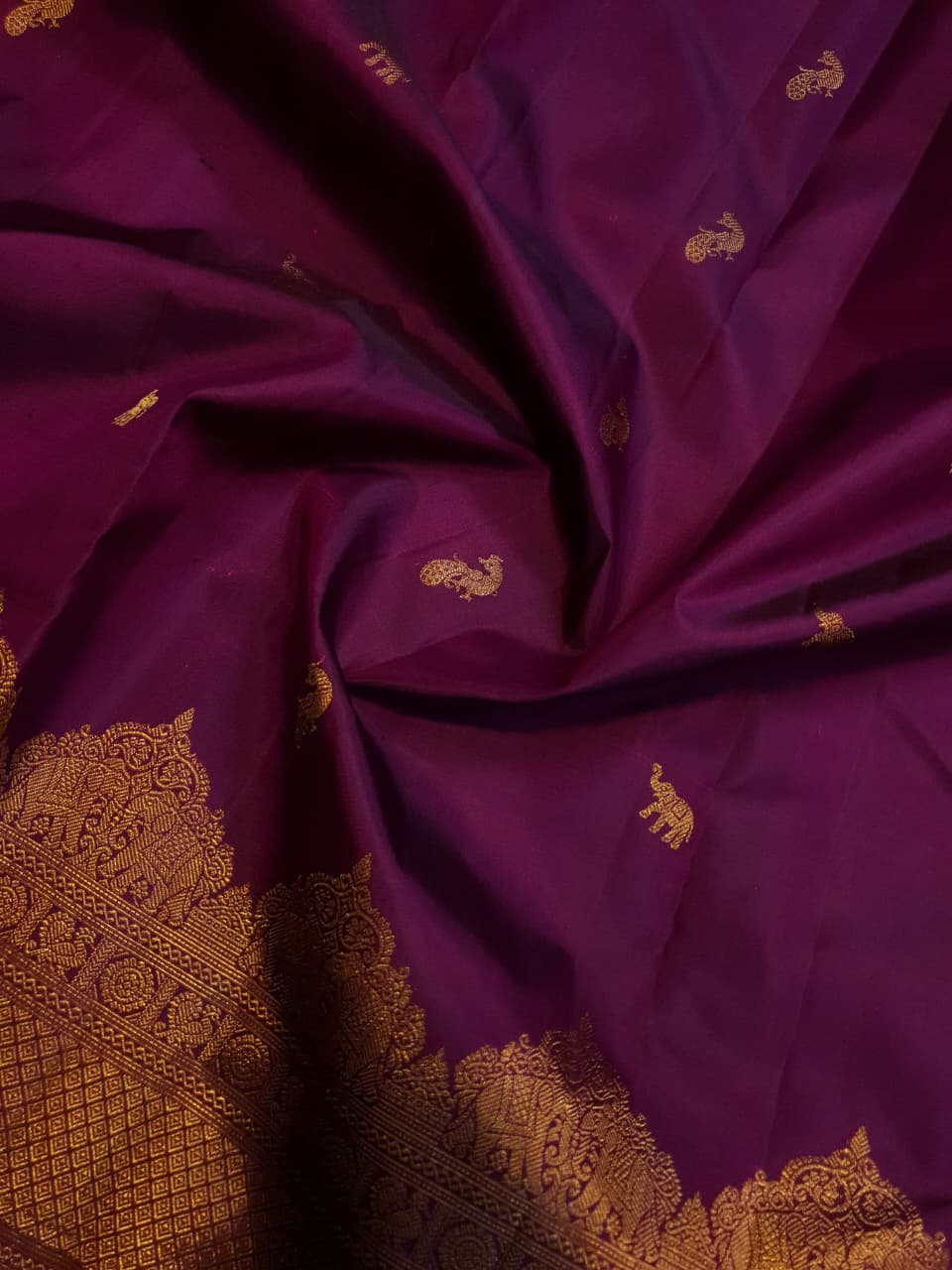 A bride in a traditional South Indian temple wears the intricate Magenta Kanchipuram Handloom 2G Gold Vairaoosi Silk Saree with matching temple jewelry.