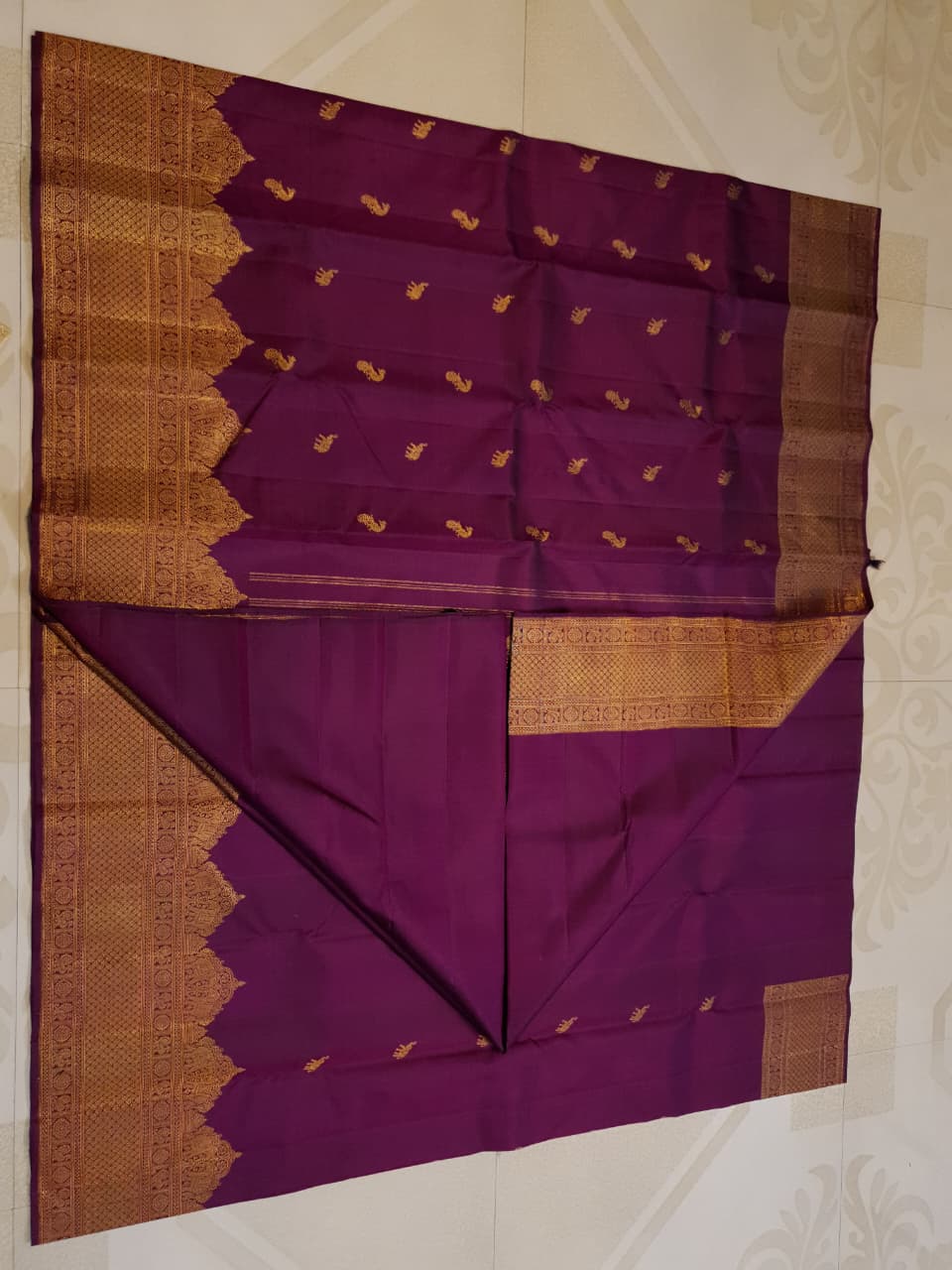 A bride in a traditional South Indian temple wears the intricate Magenta Kanchipuram Handloom 2G Gold Vairaoosi Silk Saree with matching temple jewelry.