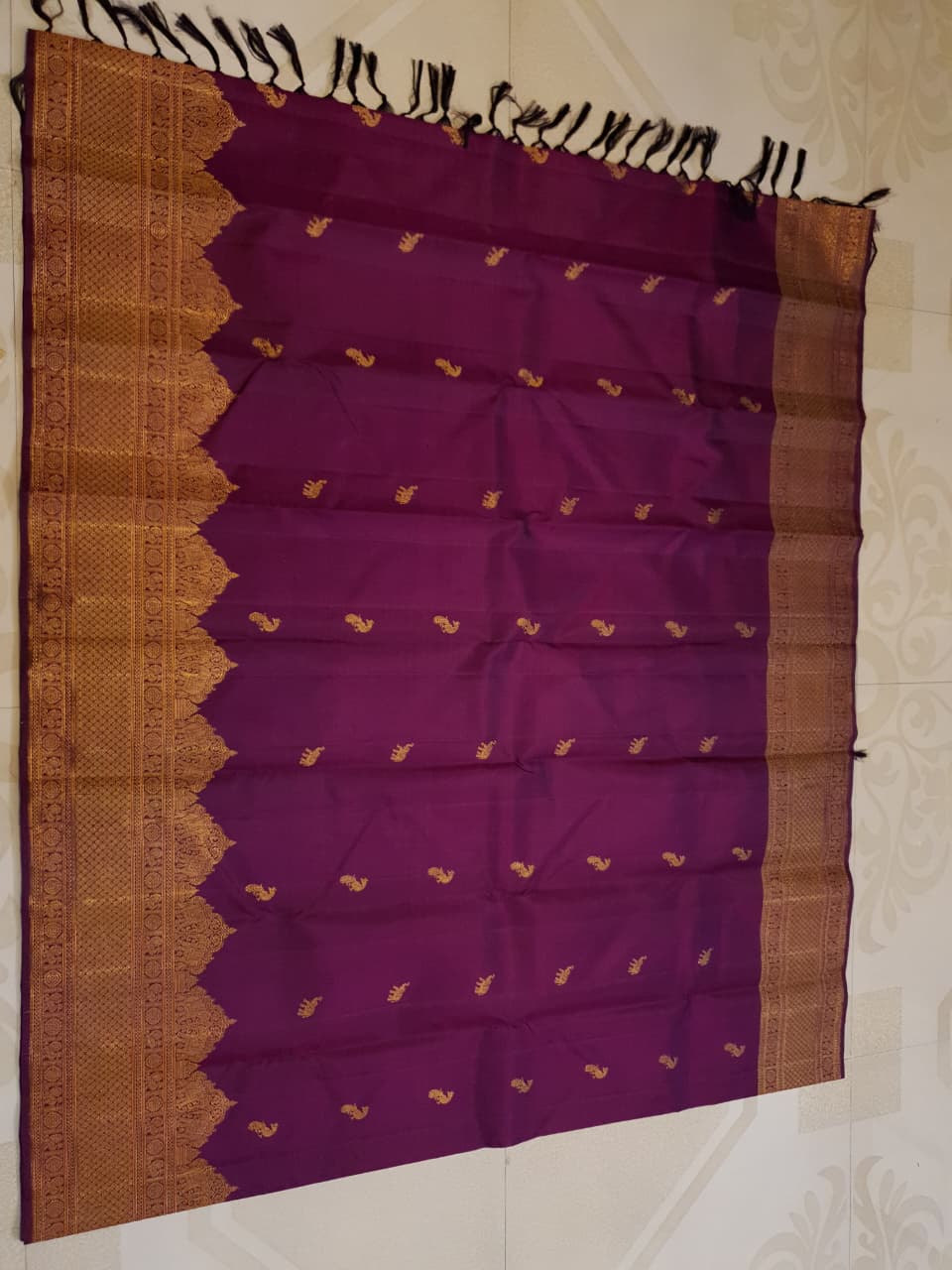 A bride in a traditional South Indian temple wears the intricate Magenta Kanchipuram Handloom 2G Gold Vairaoosi Silk Saree with matching temple jewelry.