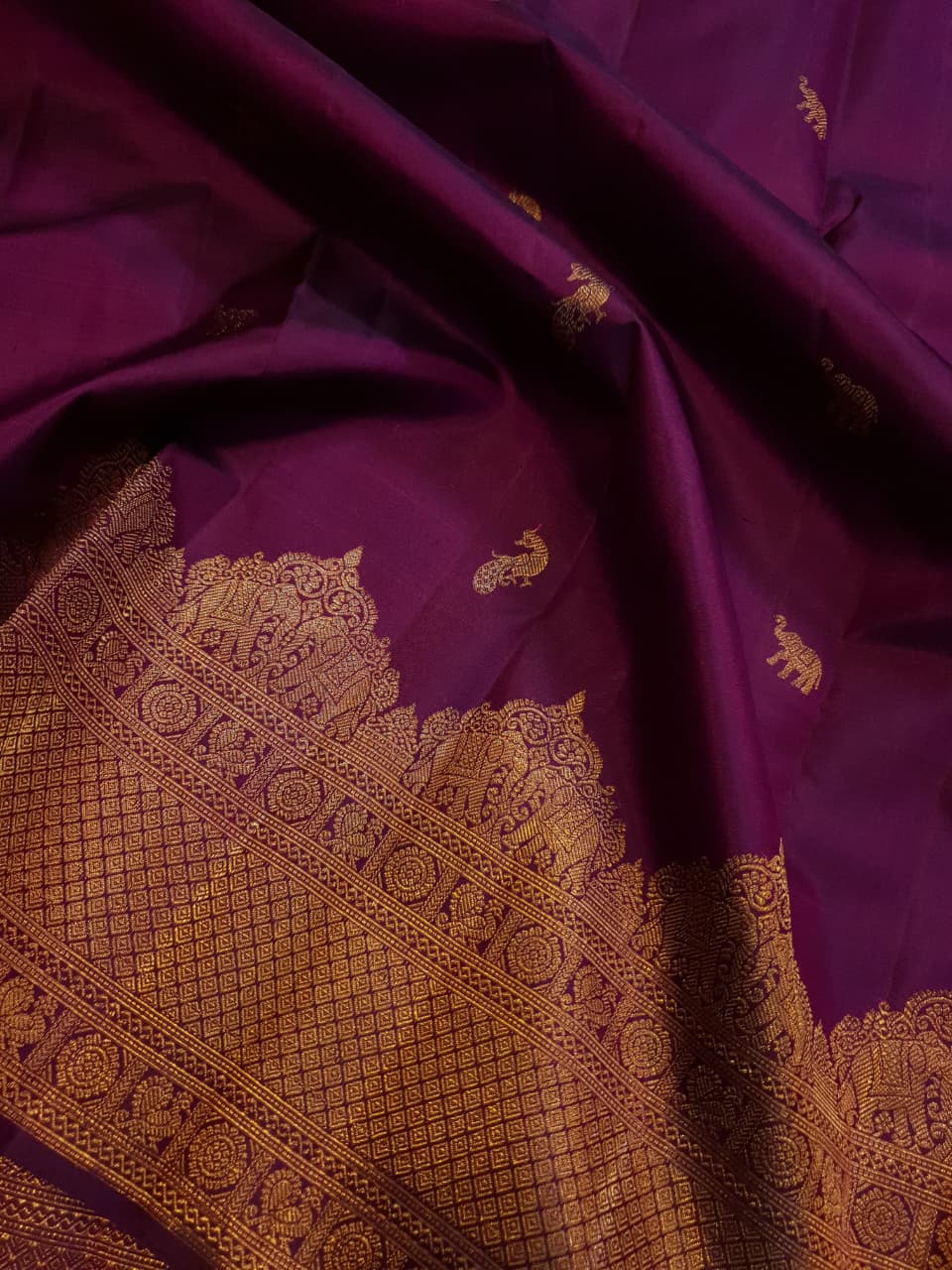 A bride in a traditional South Indian temple wears the intricate Magenta Kanchipuram Handloom 2G Gold Vairaoosi Silk Saree with matching temple jewelry.