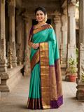 Sea Green Kanchipuram Handloom Silk Saree with small checks and a contrast purple border featuring gold zari peacock and floral patterns in a temple hallway.