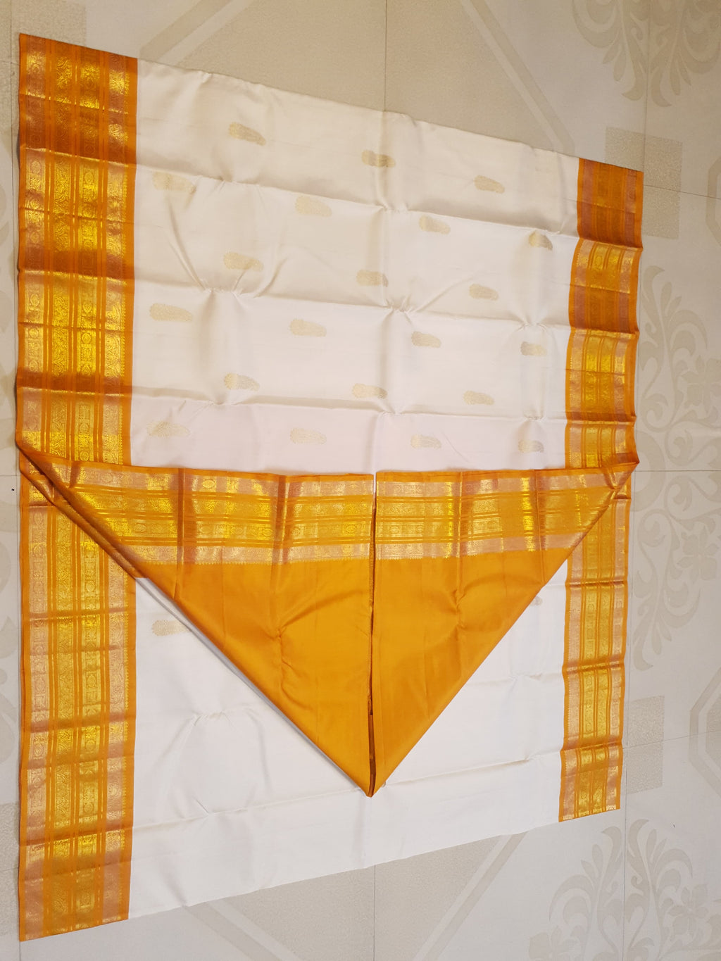 Cream and Orange Kanchipuram handloom 2G gold korvai silk saree featuring traditional gold zari weaving and classic paisley buttis.