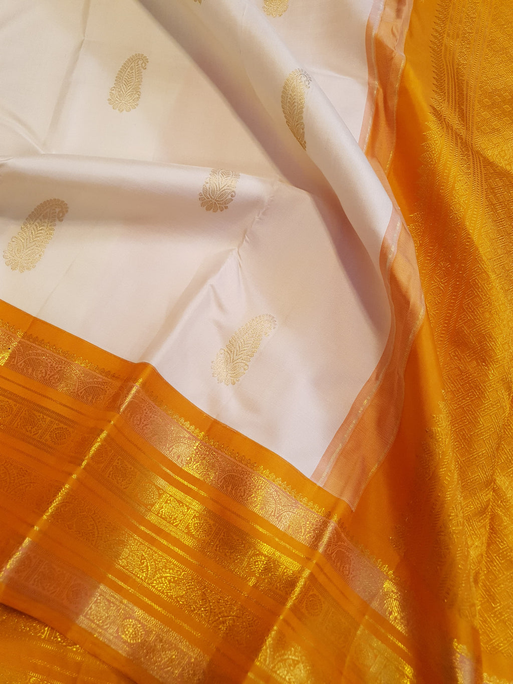 Cream and Orange Kanchipuram handloom 2G gold korvai silk saree featuring traditional gold zari weaving and classic paisley buttis.