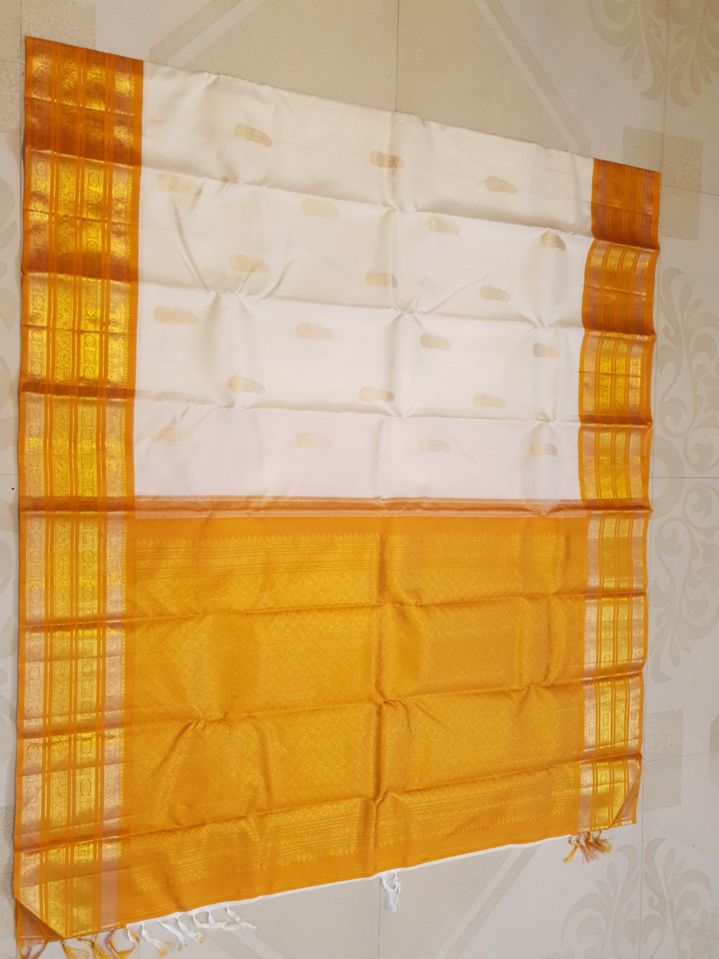 Cream and Orange Kanchipuram handloom 2G gold korvai silk saree featuring traditional gold zari weaving and classic paisley buttis.