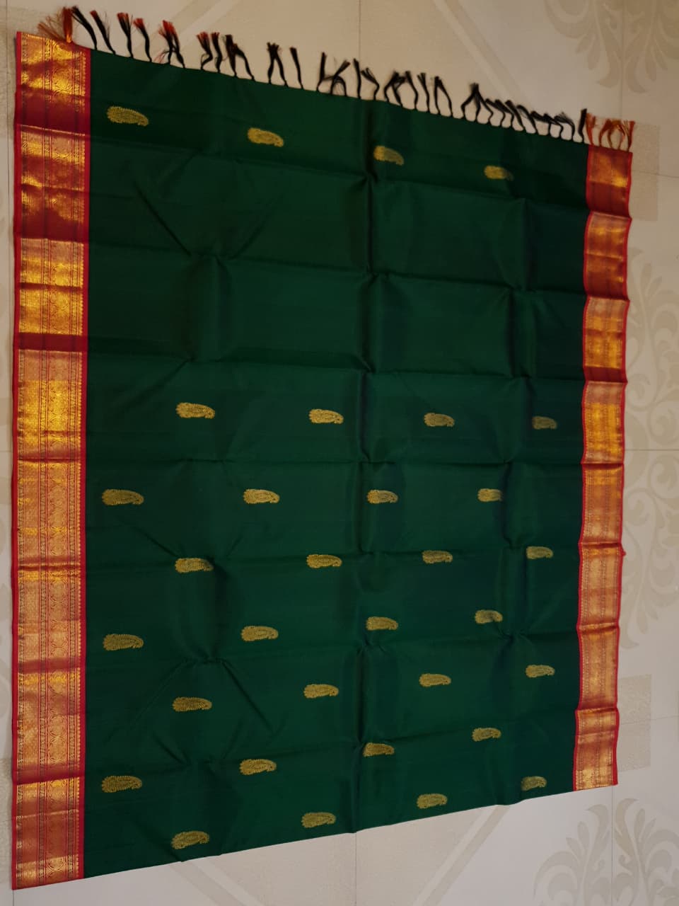 Bottle green Kanchipuram handloom Korvai silk saree, showcasing the intricate 2G gold zari motifs across the body, a vibrant contrasting pink and gold border, seamless Korvai interlocking craftsmanship, and an accompanying Silk Mark certification tag guaranteeing pure silk authenticity.