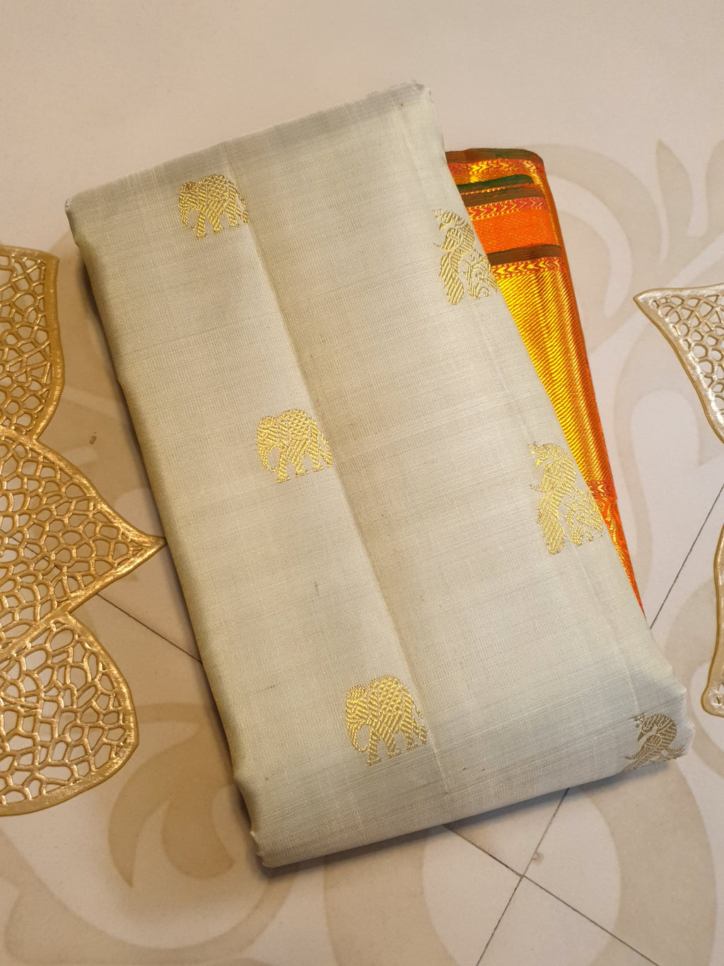 Beige Kanchipuram handloom 2G gold korvai silk saree with a striking orange and gold zari border.