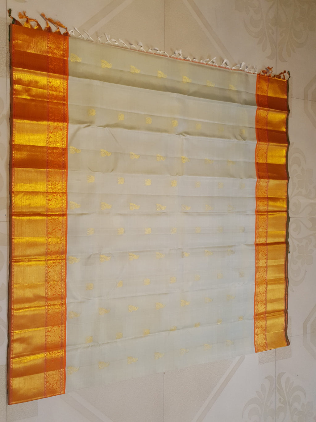 Beige Kanchipuram handloom 2G gold korvai silk saree with a striking orange and gold zari border.