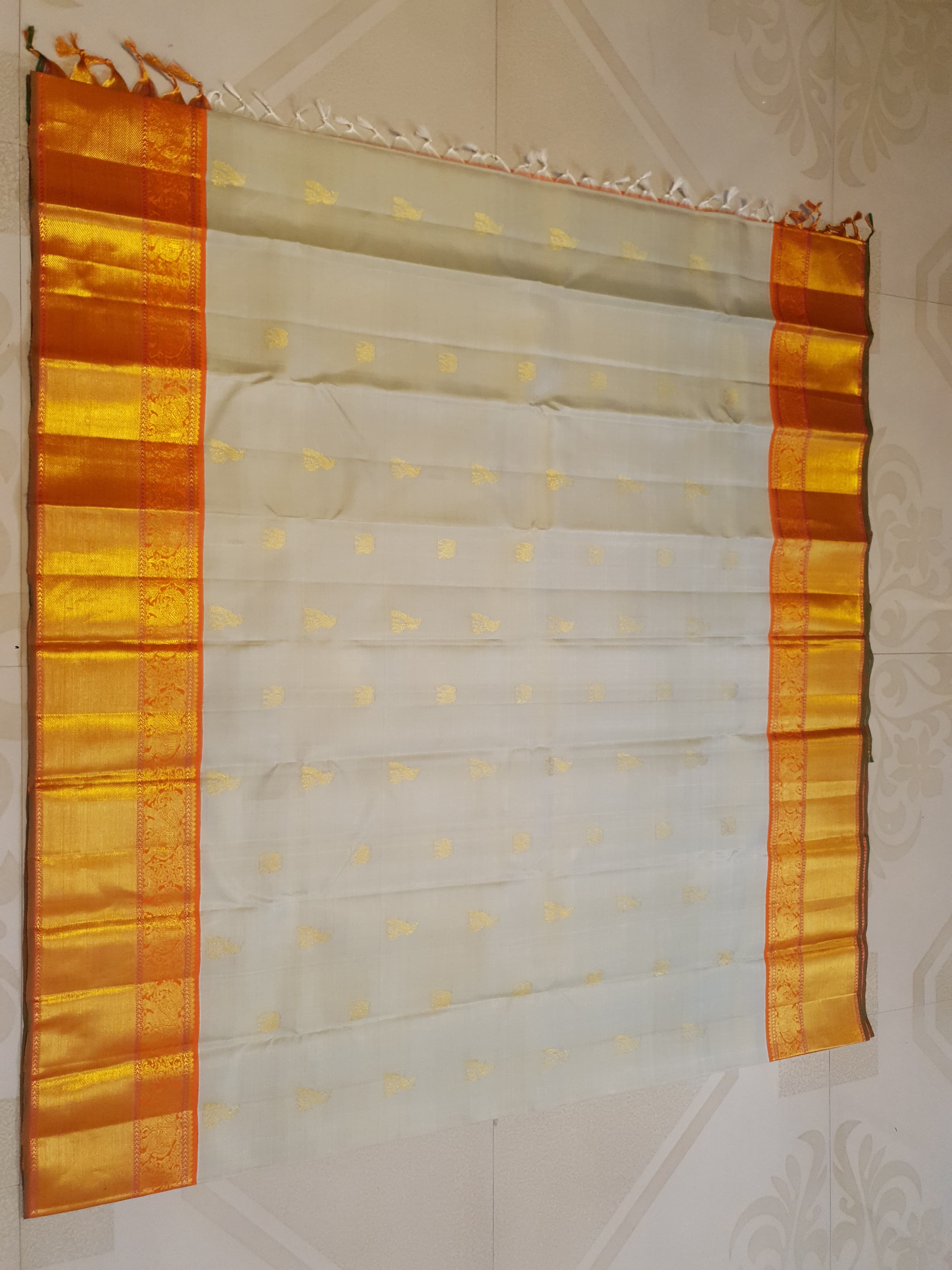 Beige Kanchipuram handloom 2G gold korvai silk saree with a striking orange and gold zari border.
